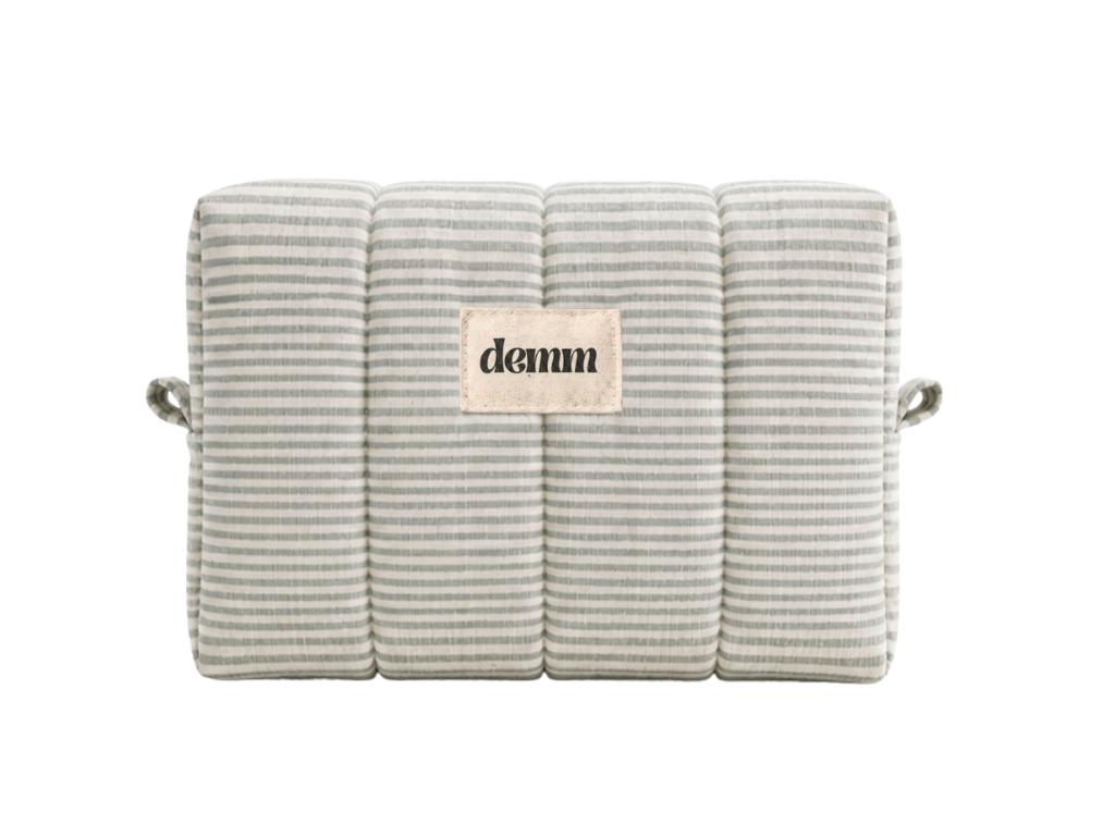 A handmade green striped quilted make up bag with the brand name 'DEMM'.