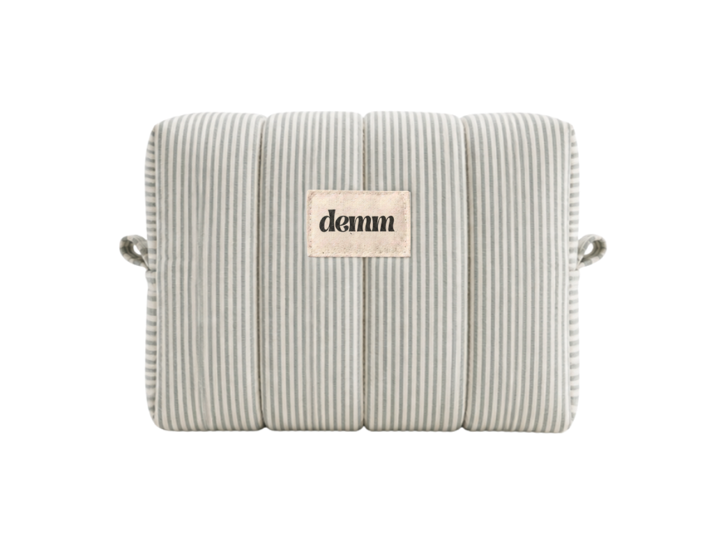 A handmade green striped quilted make up bag with the brand name 'DEMM'.