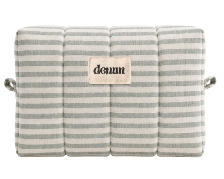 A handmade green striped quilted make up bag with the brand name 'DEMM'.