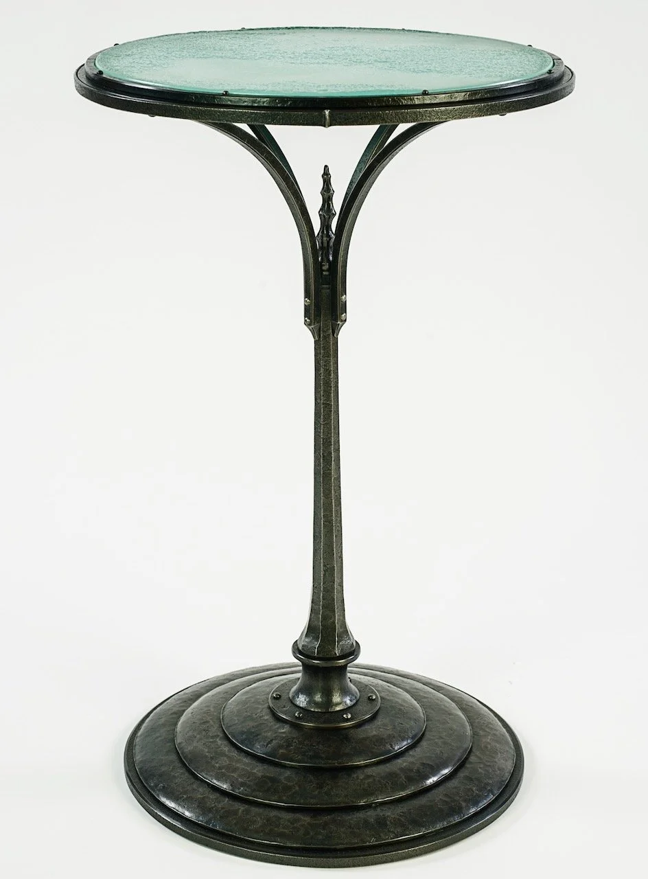 Sculptural steampunk hand forged iron table with cast glass round top