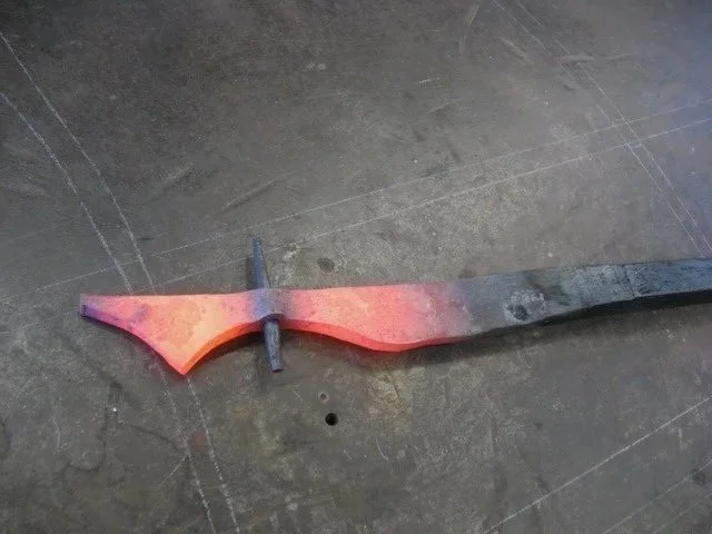 A glowing hot metal piece being shaped on an anvil, with a red-orange color indicating high temperature.