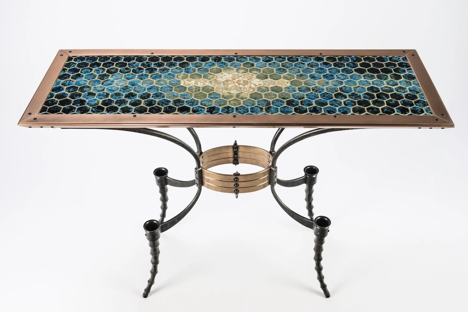 A rectangular table with a honeycomb-patterned ceramic tile top and metal legs.