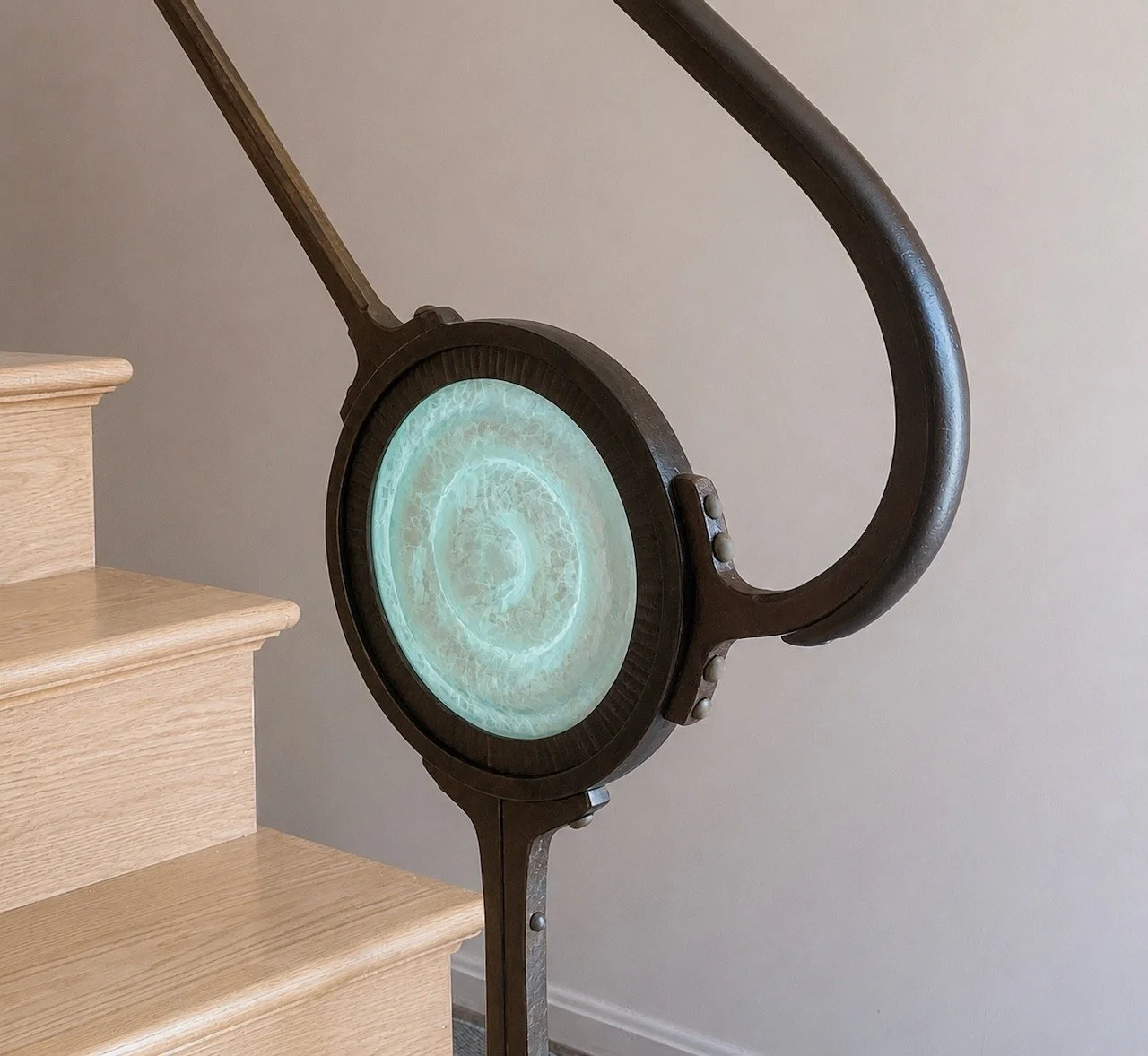 Forged iron interior handrail with cast glass inset medallion