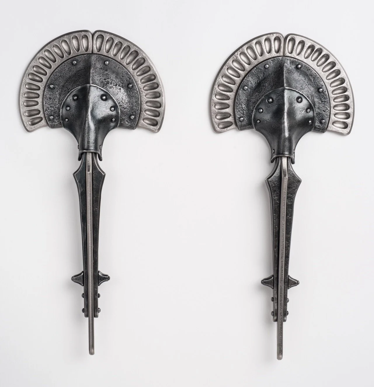 Two decorative wall hooks shaped like elephants with long trunks, made of dark metal, mounted on a white wall.