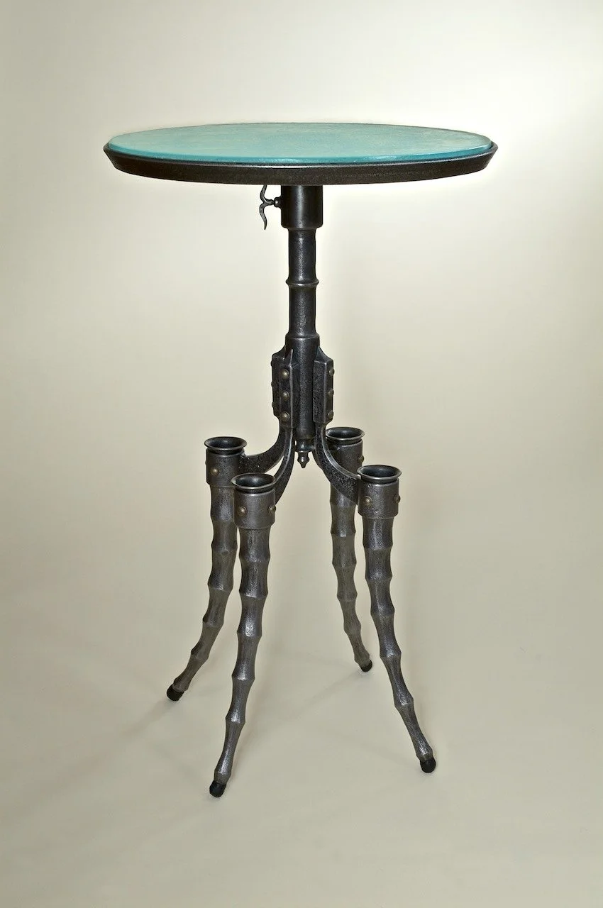 Sculptural steampunk hand forged iron table with cast glass round top