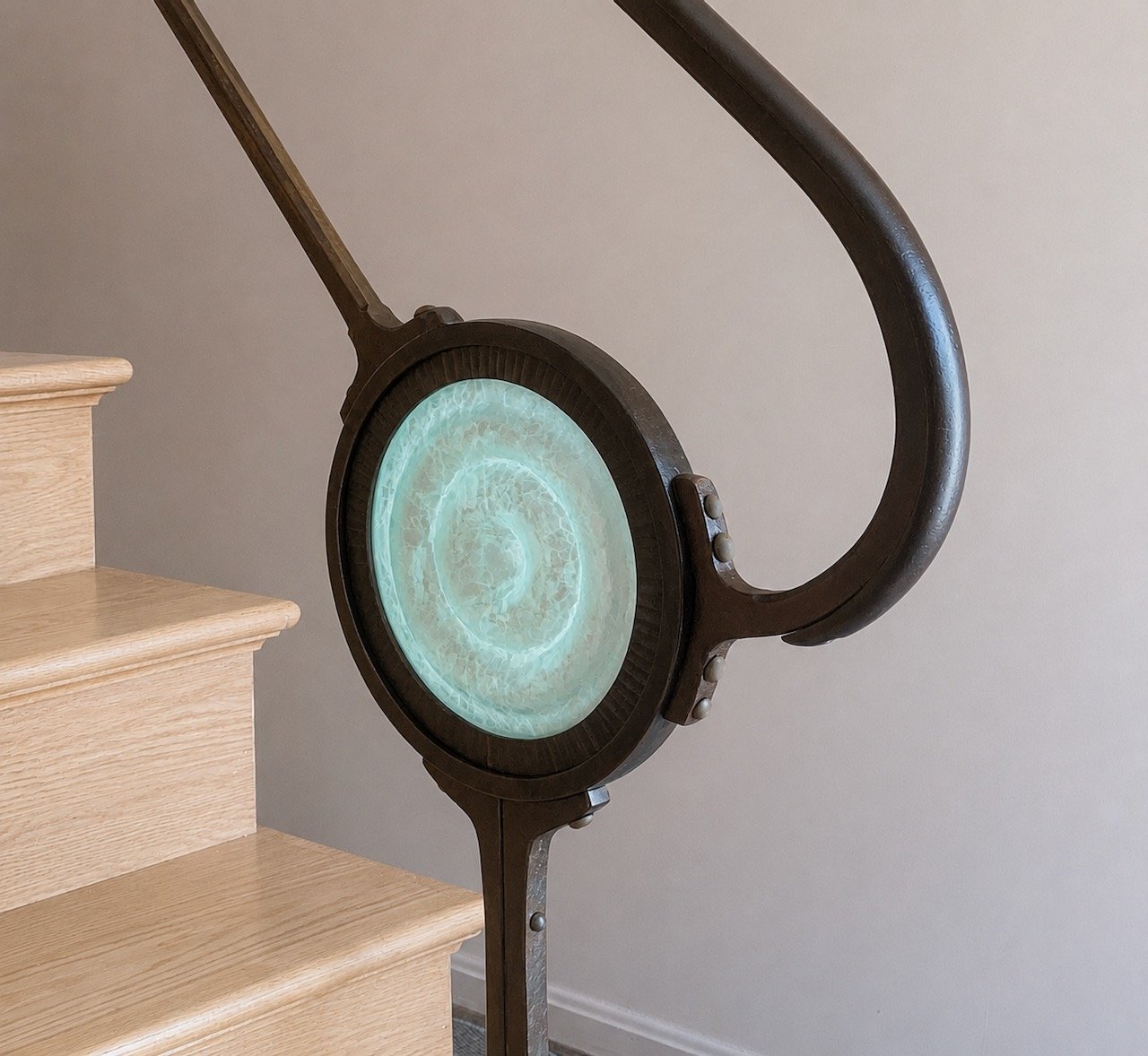 Forged iron steampunk interior handrail with cast glass inset medallion