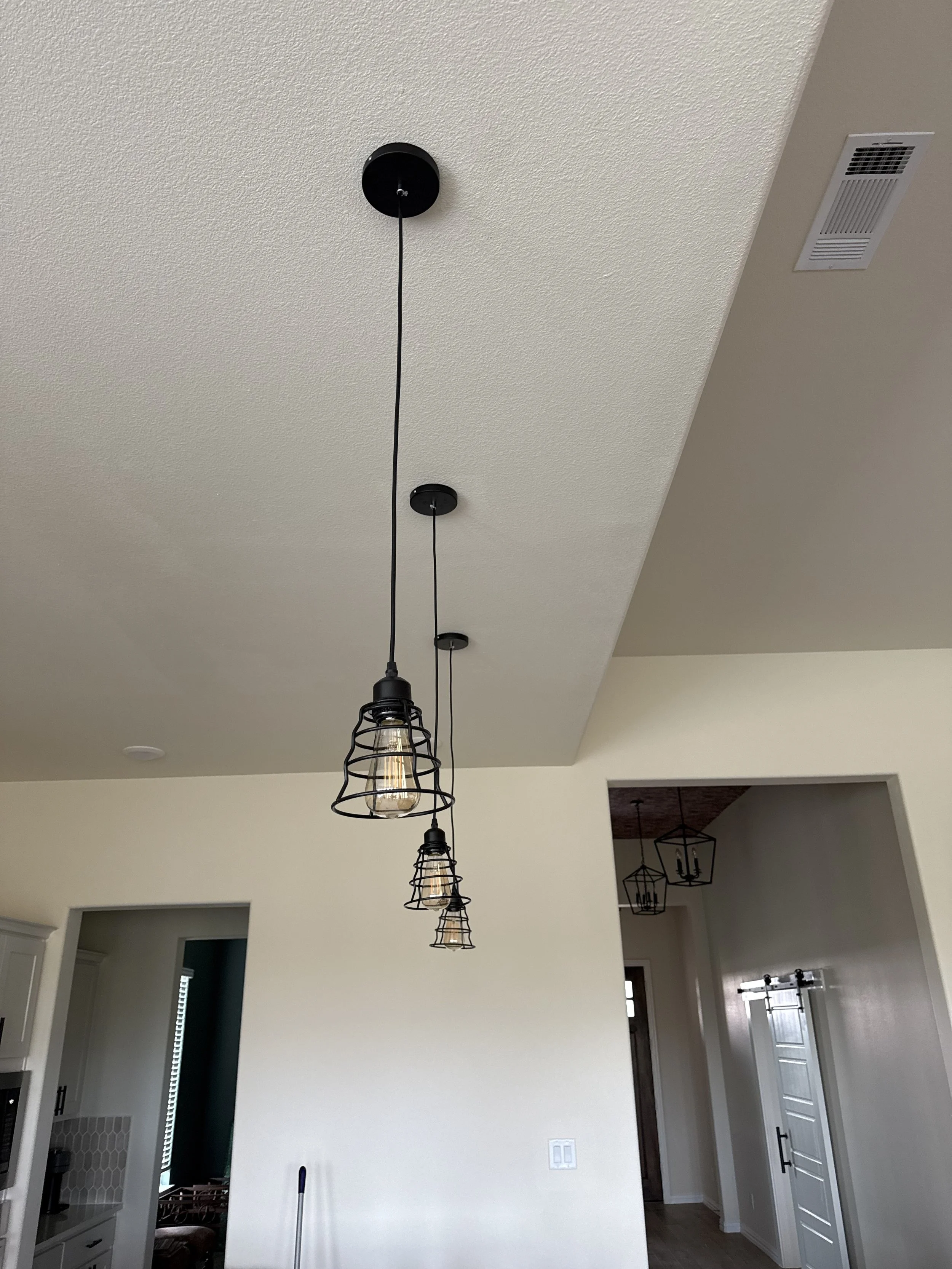 Wire cage pendant light freshly installed during an in-progress kitchen lighting update by MZL Construction
