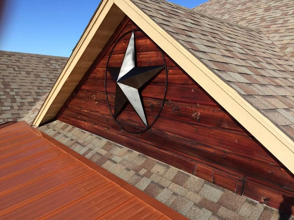 The image shows the exterior of a house with a wooden gable, a metal star decoration, and a shingled roof. The star is mounted on the wooden gable.