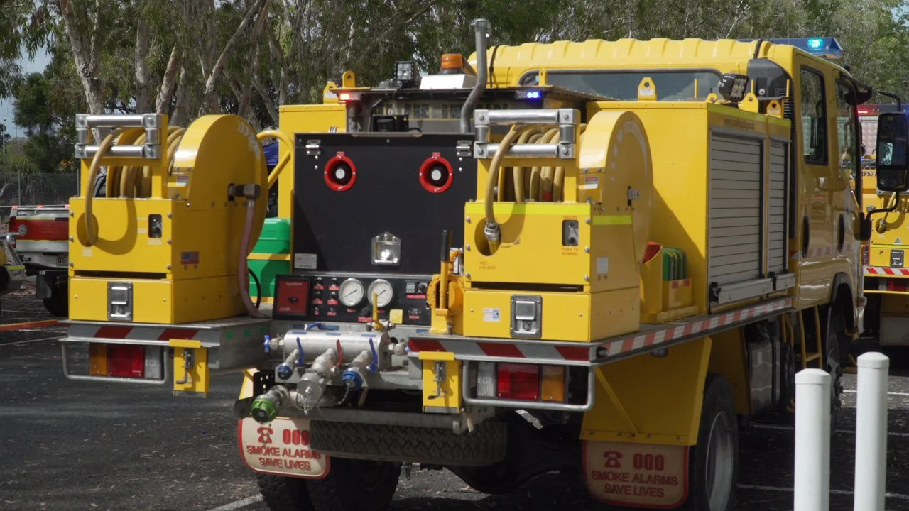 A yellow firefighting vehicle with equipment, hoses, and gauges for fire suppression.
