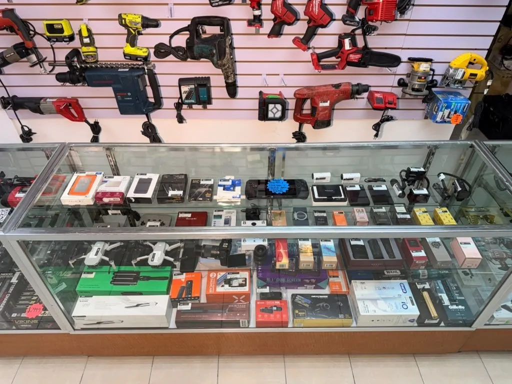 Casa de Empeño en San Pablo del Monte Tlaxcala Muestra de herramientas eléctricas en una tienda, incluyendo sierras, taladros y baterías, con productos electrónicos y accesorios en vitrina.