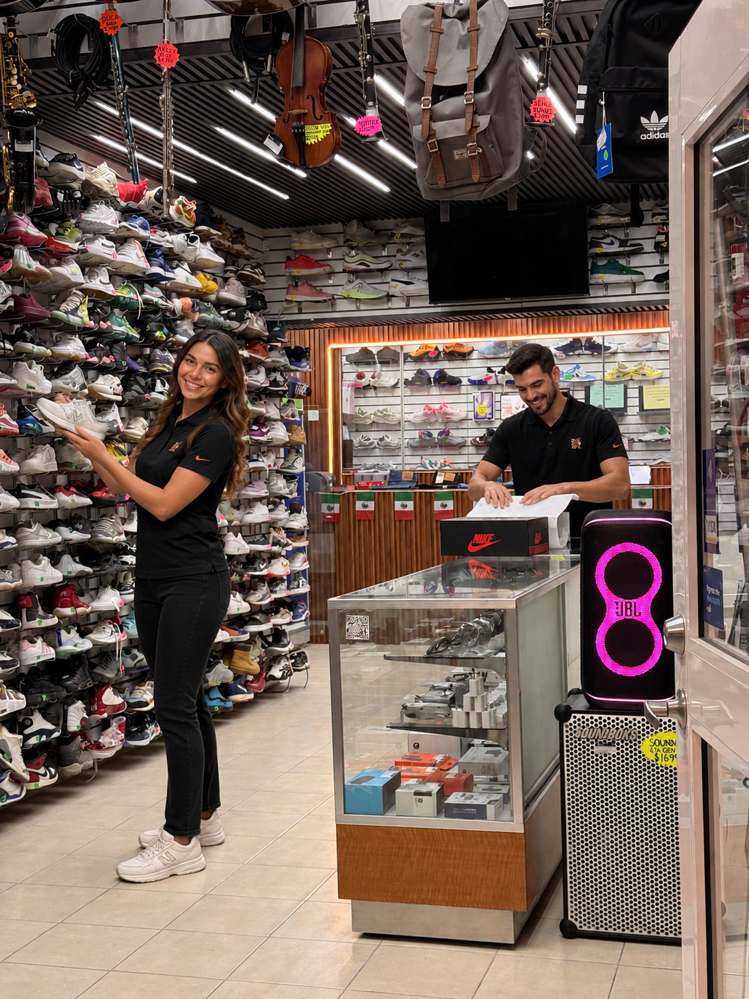 Persona mujer eligiendo zapatos en una tienda de calzado, con estanterías llenas de sneakers y zapatos deportivos, y un hombre organizando productos tras el mostrador.