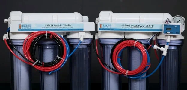 Two reverse osmosis water filtration units with red and blue tubing, mounted on a black background.
