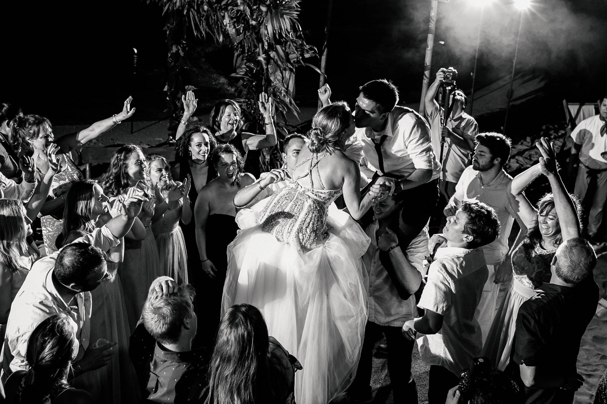 Bride and groom kissing on the dance floor during the reception of their beach wedding.