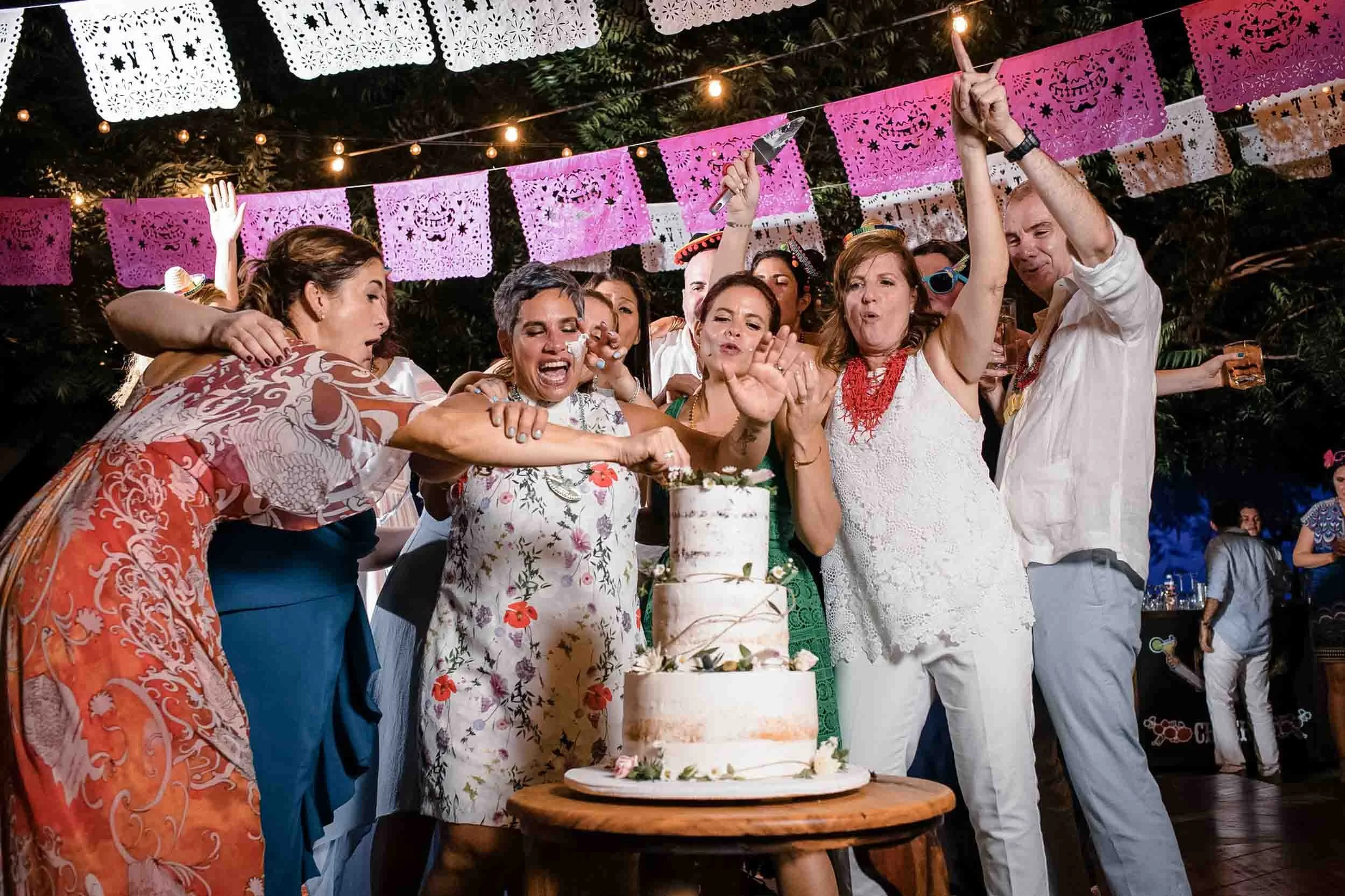 Group of people joining cake cutting having the time of their lives during the wedding reception.