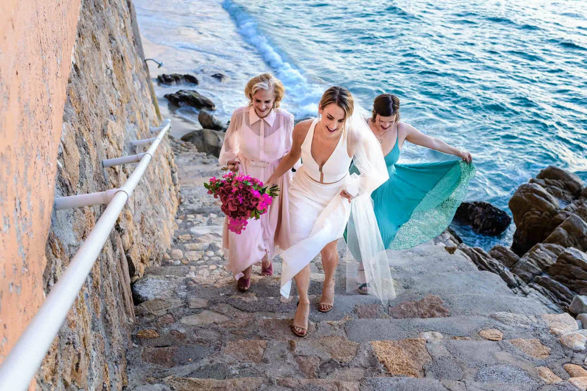 Bride walking with mother and maid of honor towards wedding ceremony