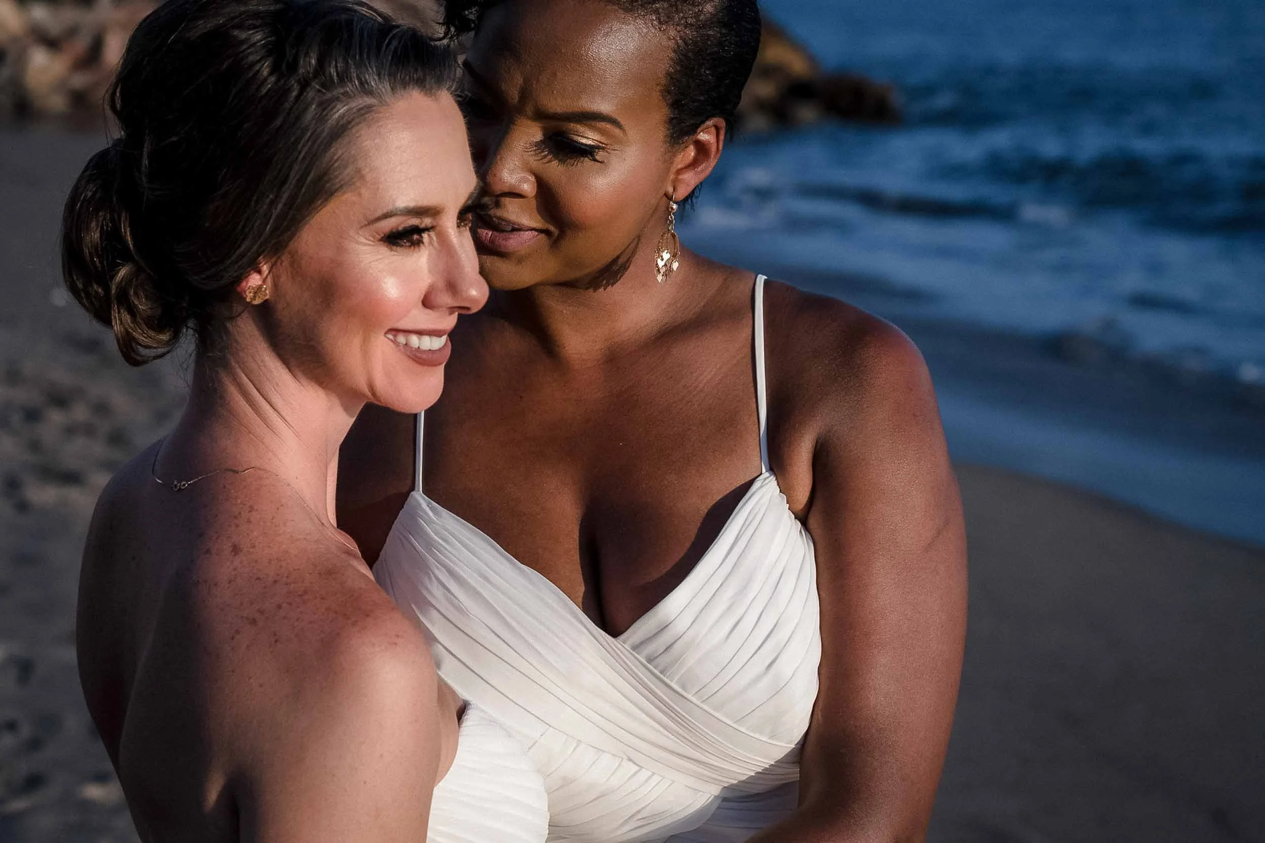 Lesbian couple posing for bridal photos after their wedding ceremony at the beach of the Marriott Resort in Puerto Vallarta