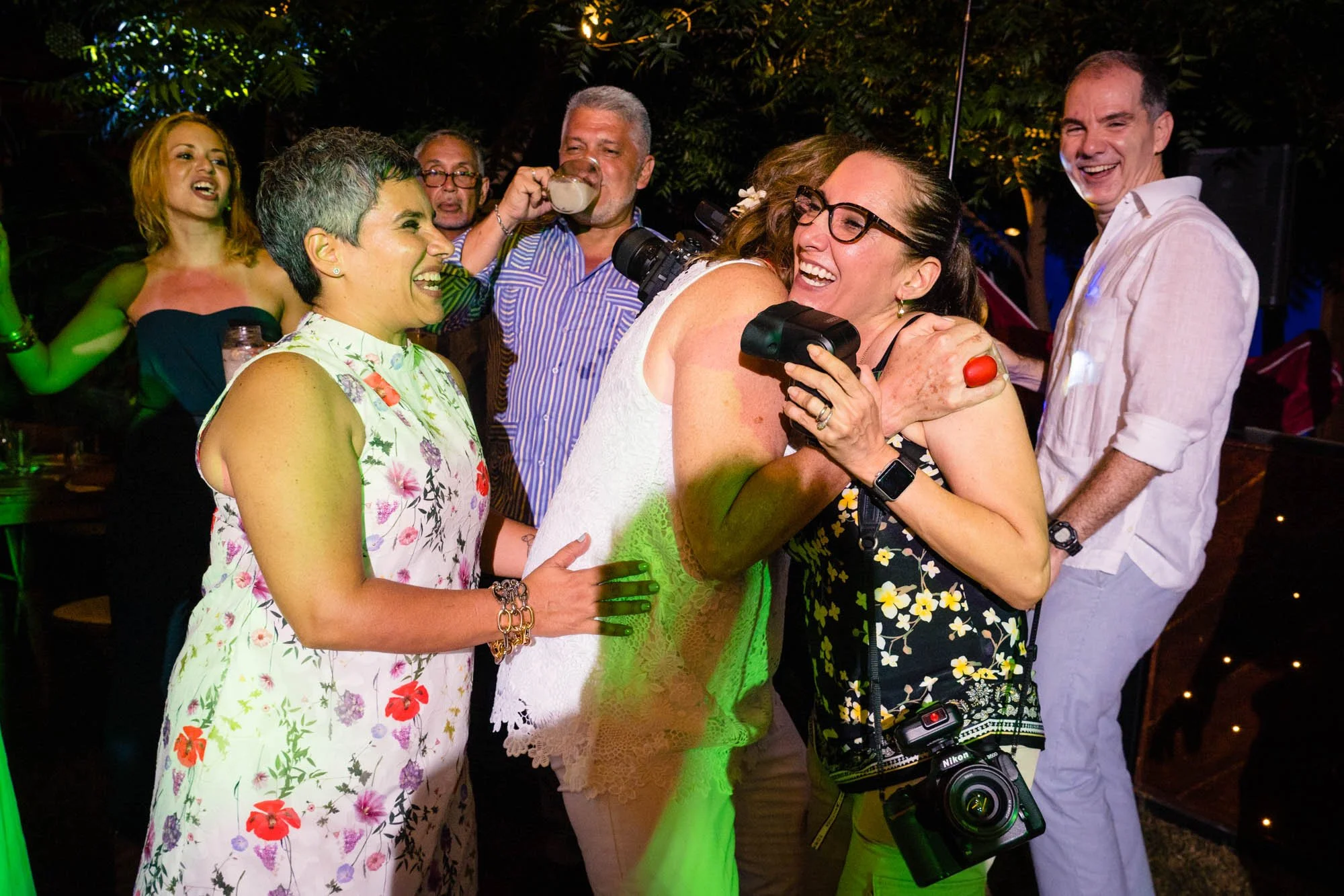 Bride hugging wedding photographer during party