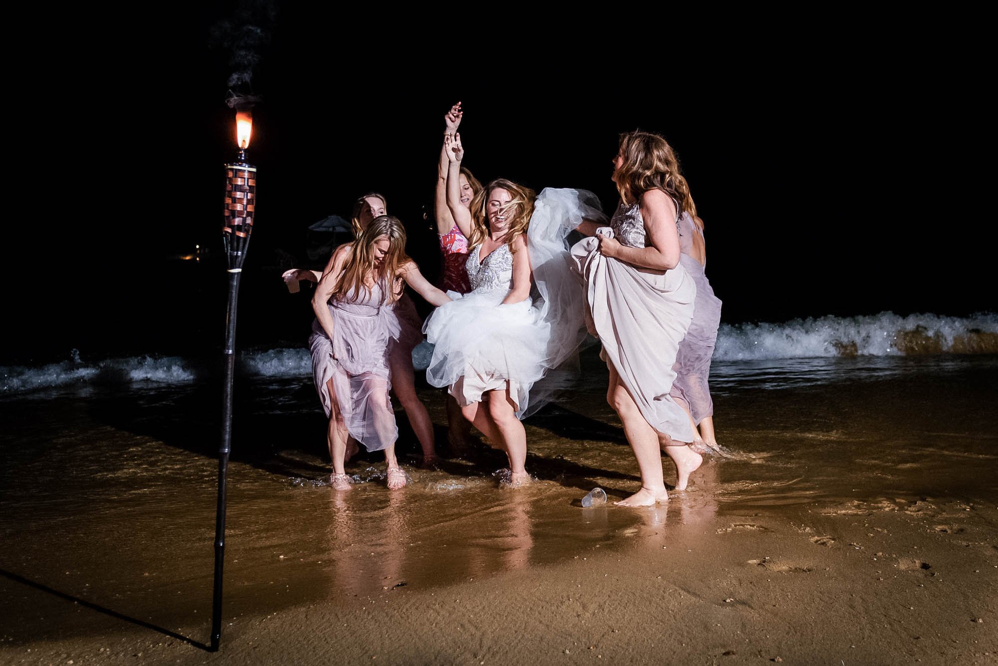 Bride and bridesmaids dancing along the shore in Las Caletas.