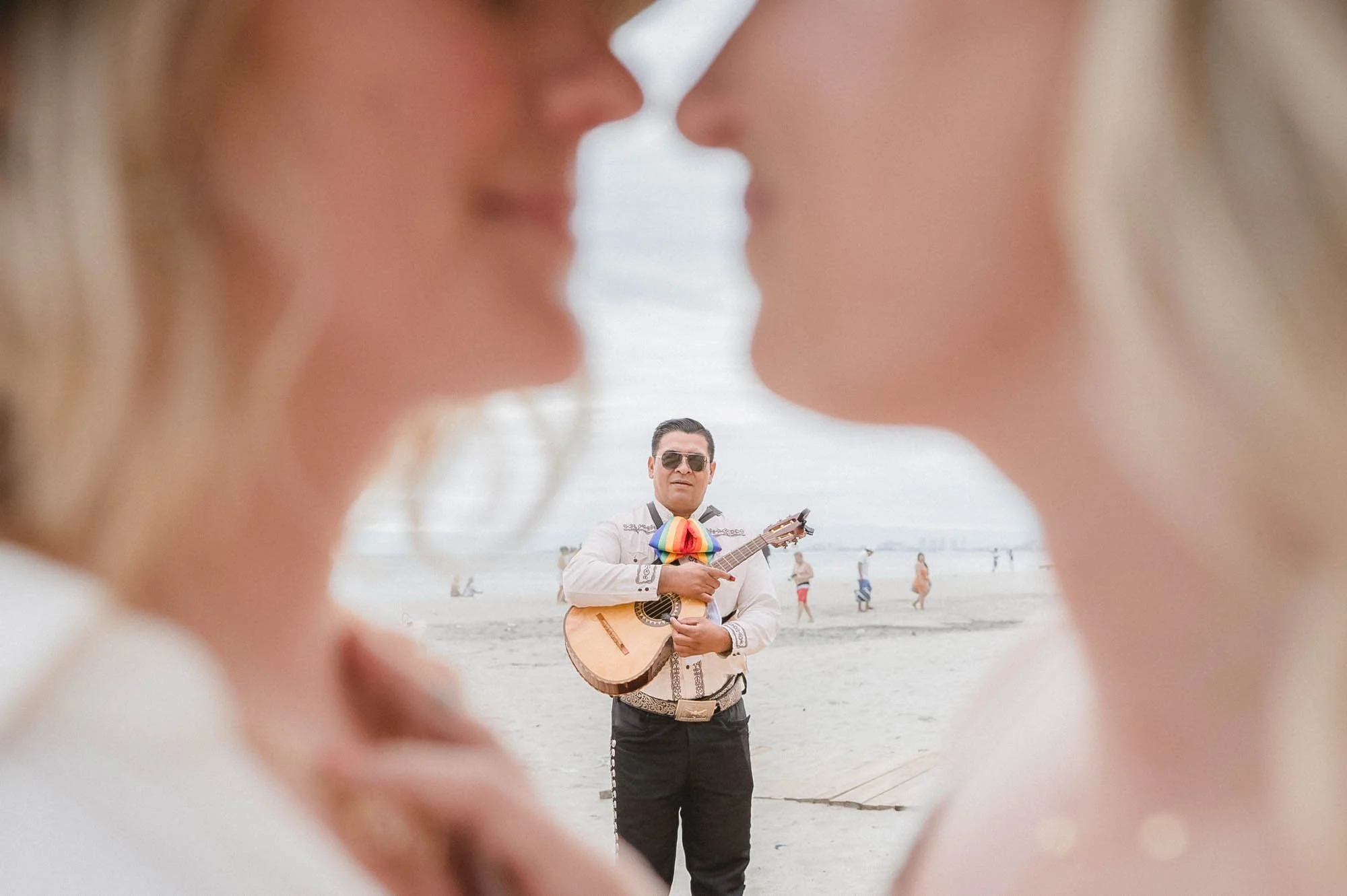 Mariachi looking at lesbian couple at beach in Puerto Vallarta