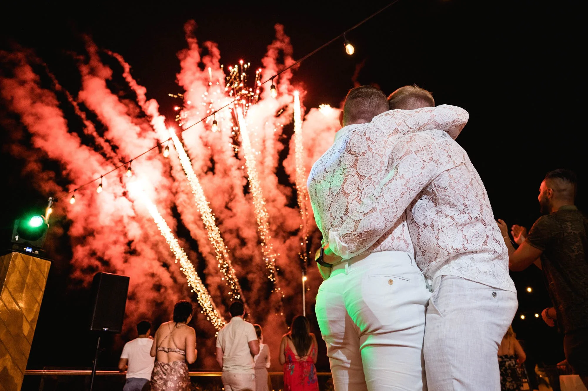 Surprise fireworks and gay grooms hugging during their wedding party at the LGBTQ friendly luxury resort Grand Miramar in Puerto Vallarta.