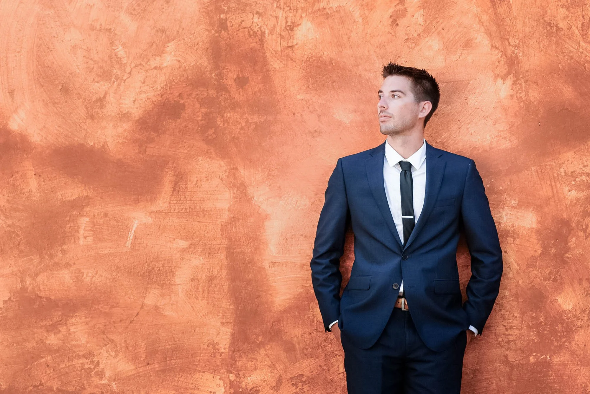 Groom posing during session in downtown.