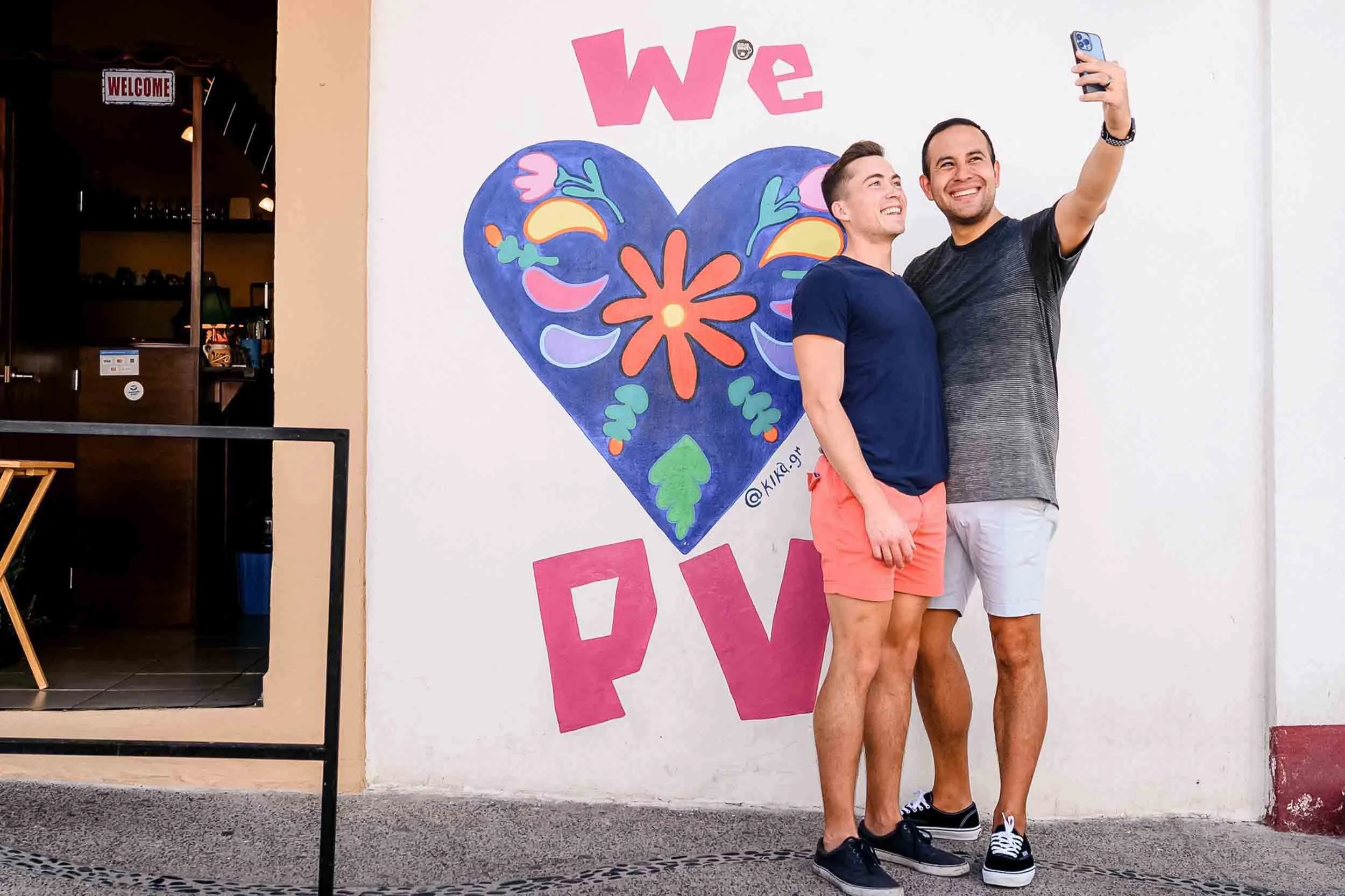 Gay couple taking selfie with wall mural