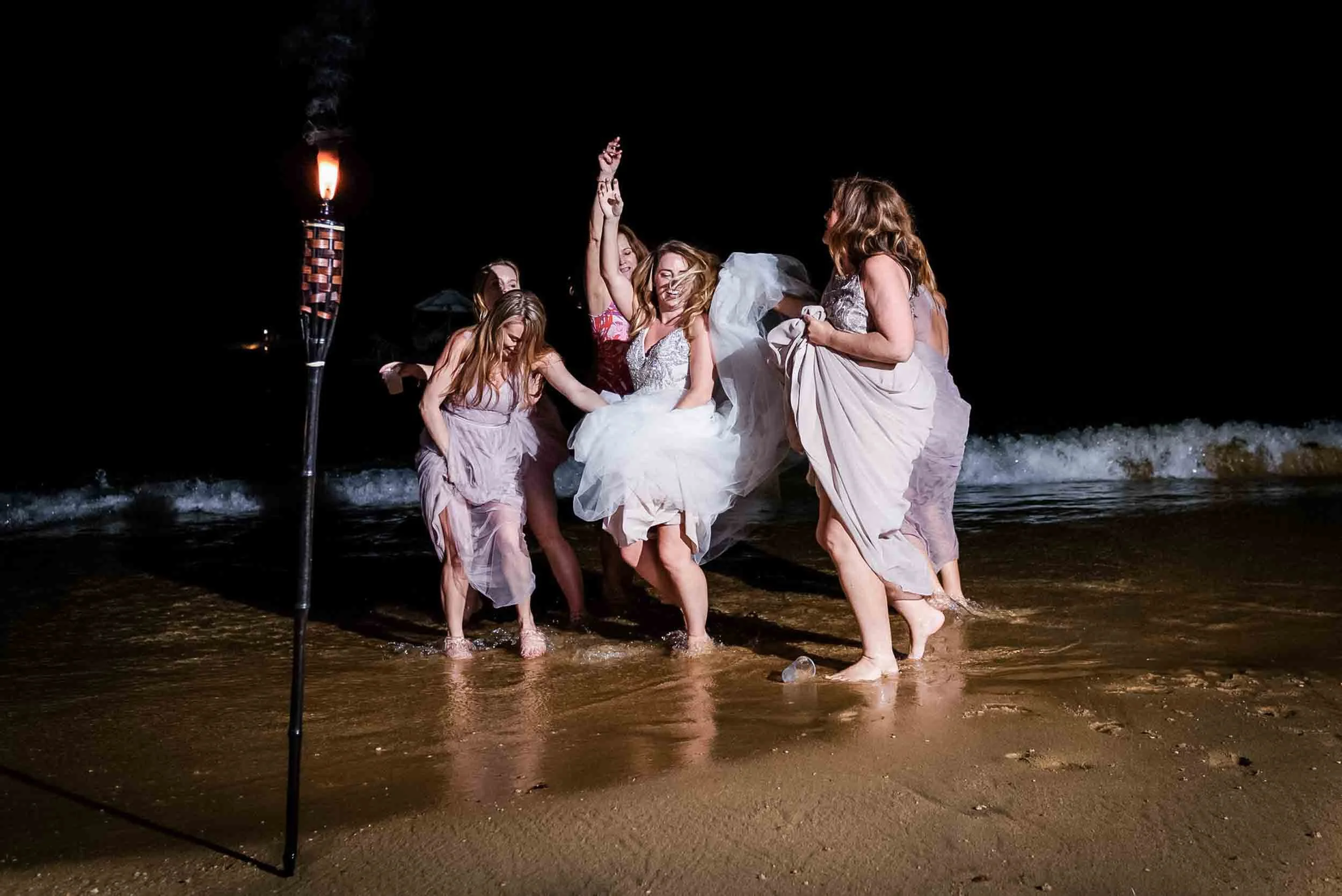 Bride and bridesmaids dancing along the shore in Vallarta