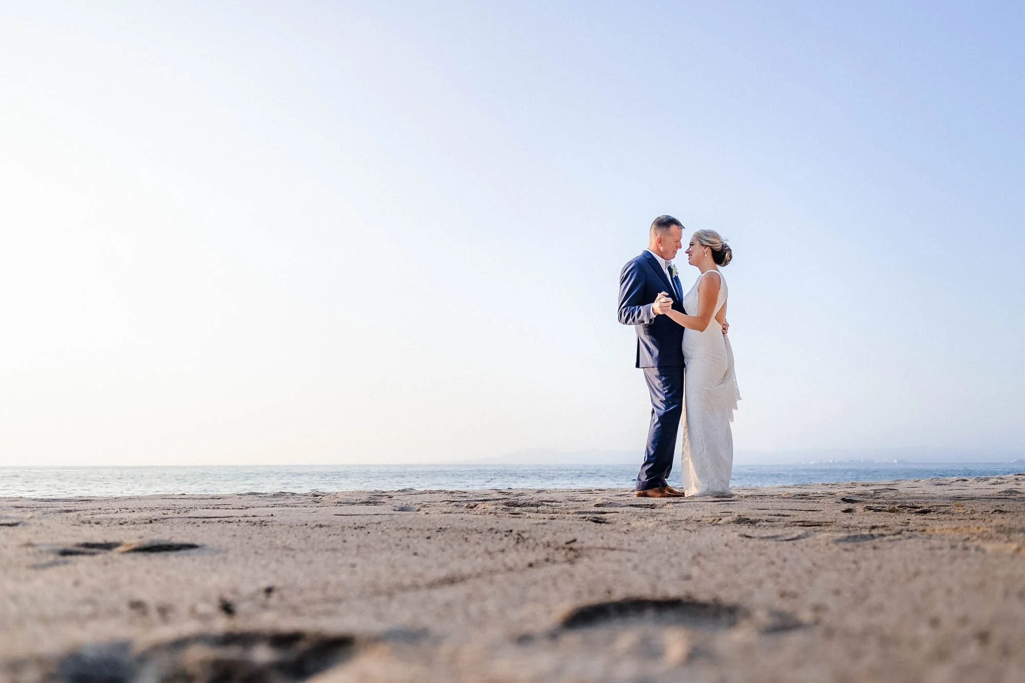 Bride and groom at beach of private villa wedding.
