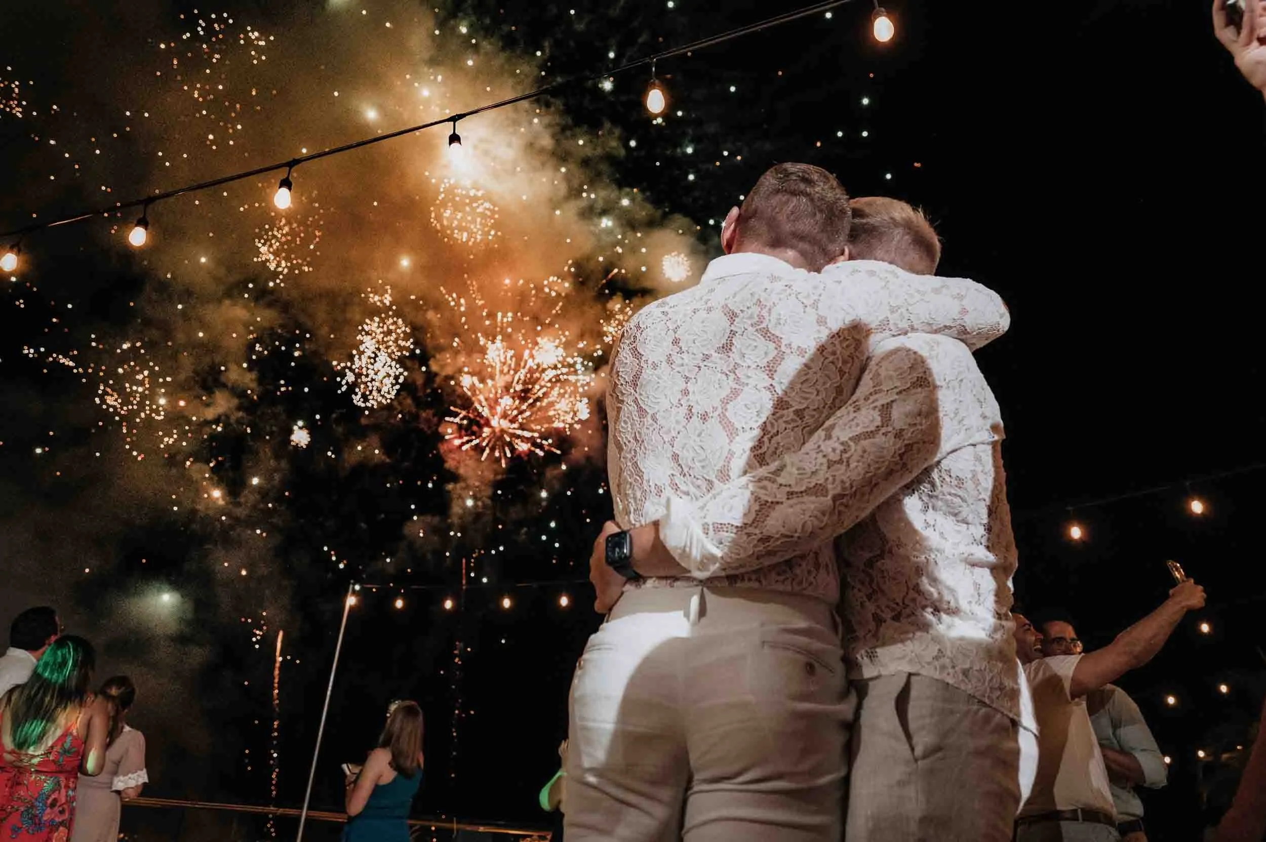 Grooms hugging during the surprise wedding fireworks they gave to each other.