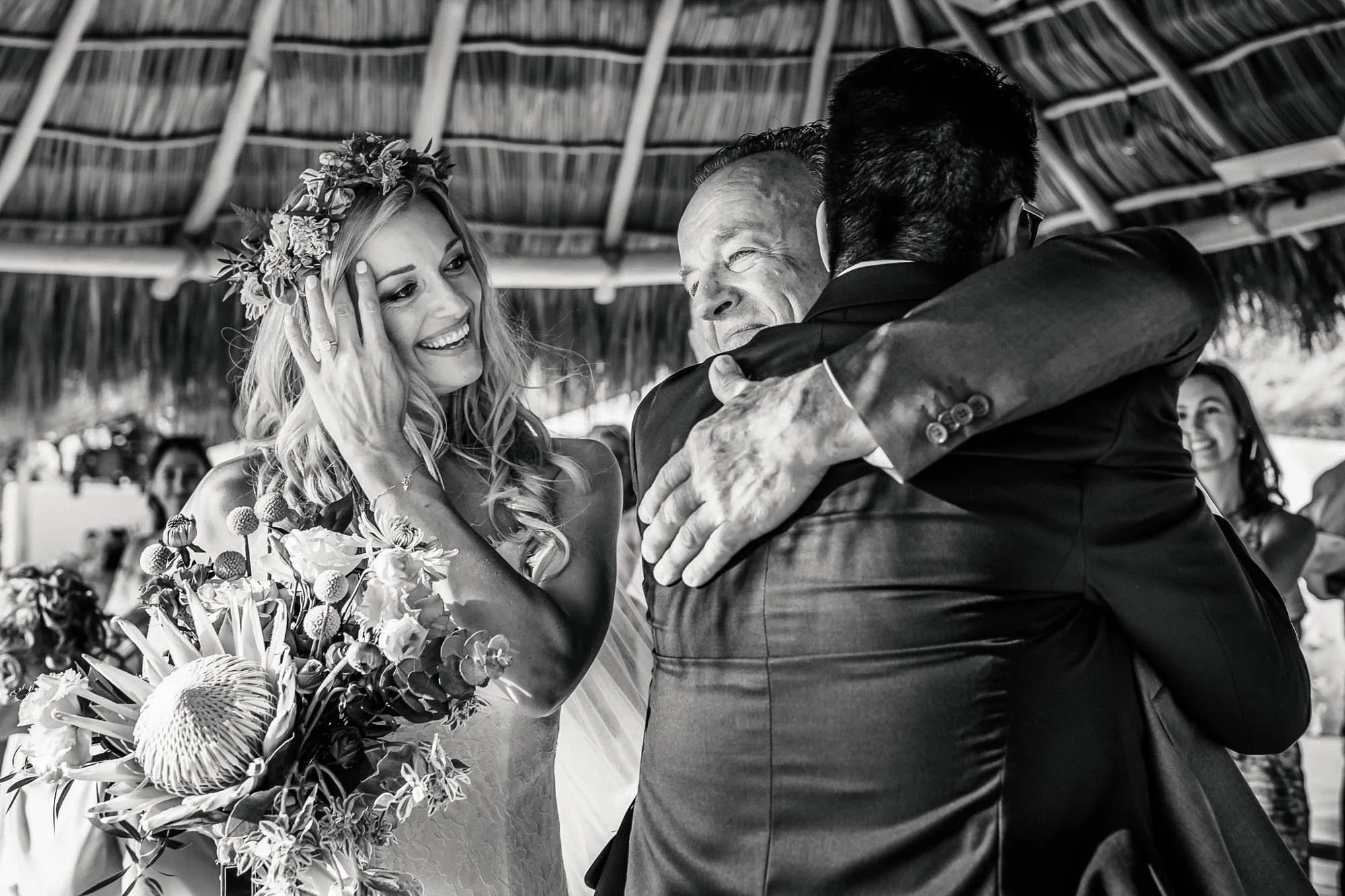 Father of the bride hugging groom during wedding ceremony