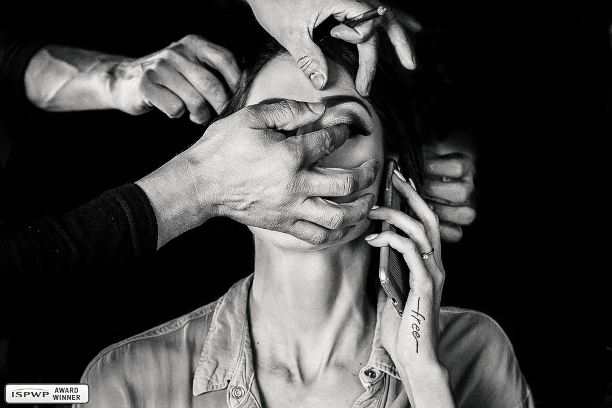 Bride getting makeup and hair done while she talks on the phone, hands take all the attention in the scene.