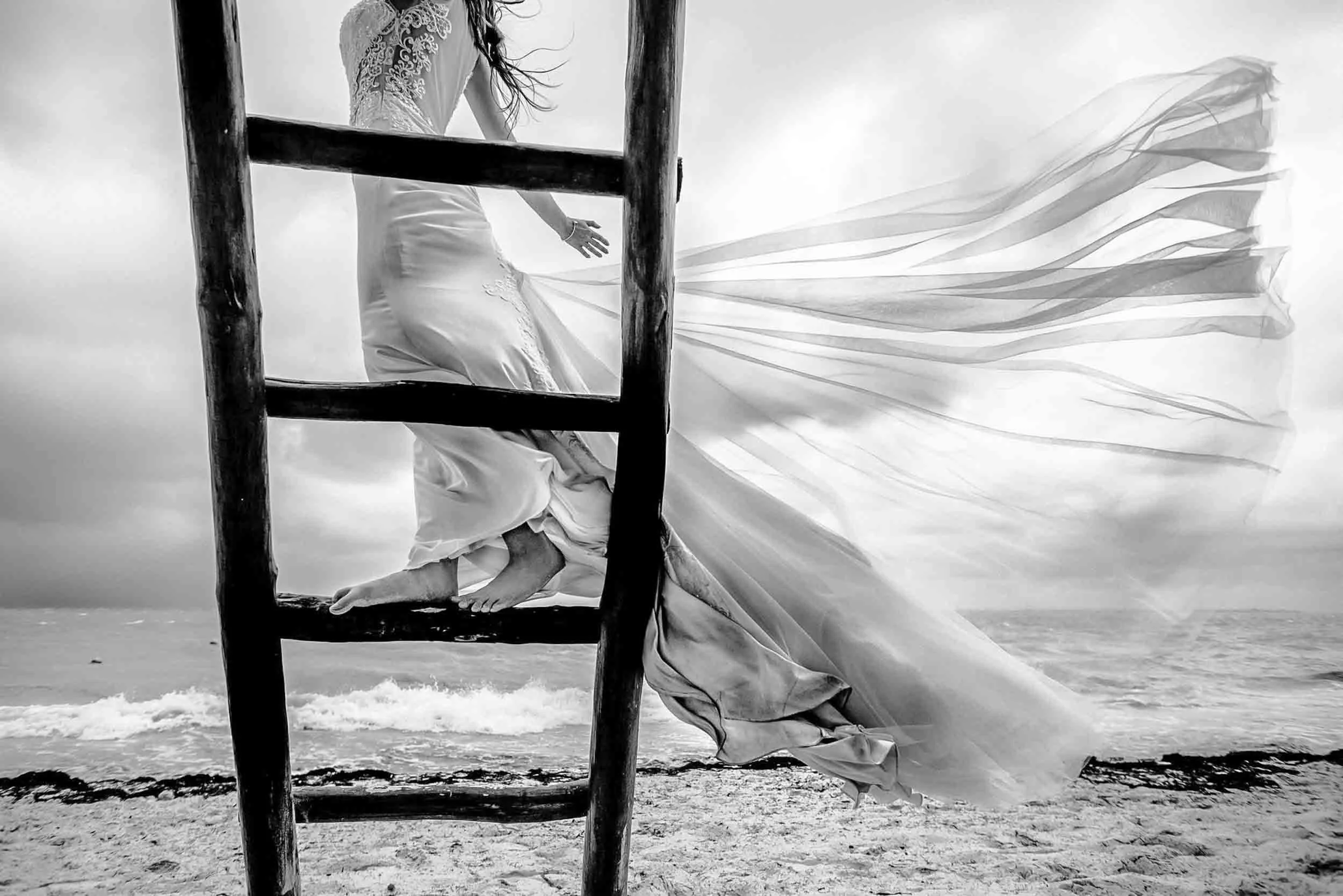 Flying wedding dress train from the strong winds at the beach in Mexico.