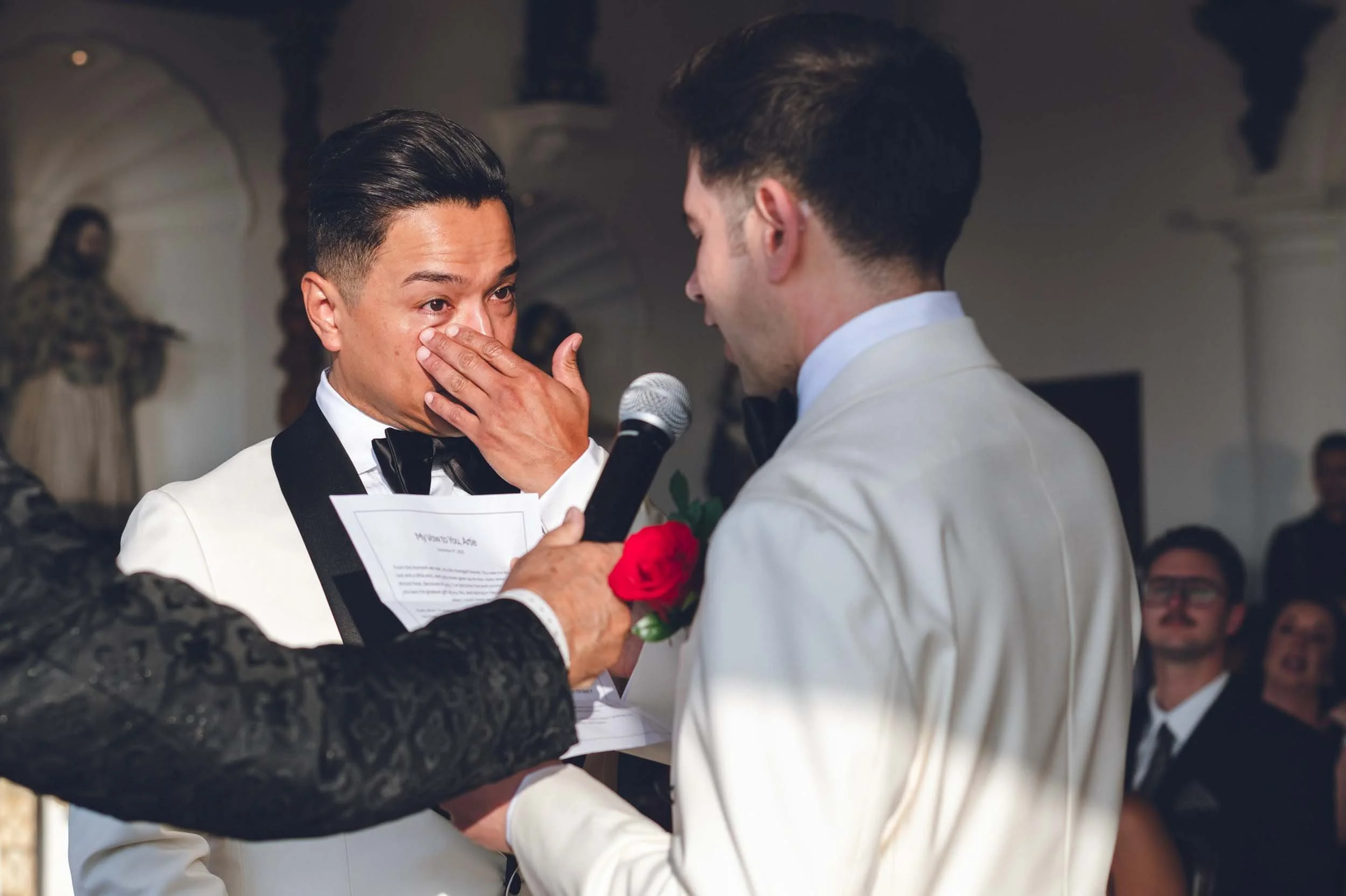 Emotional ceremony vows of gay couple during their wedding ceremony with a formal attire at a luxurious venue. 