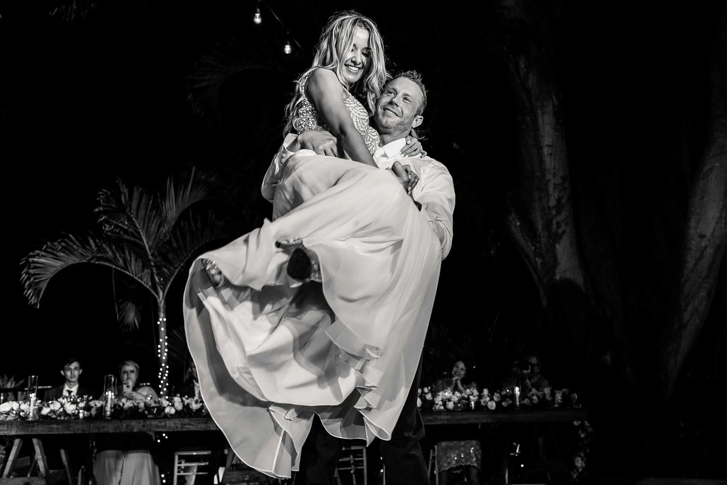 Groom lifting bride during first dance at their wedding reception.