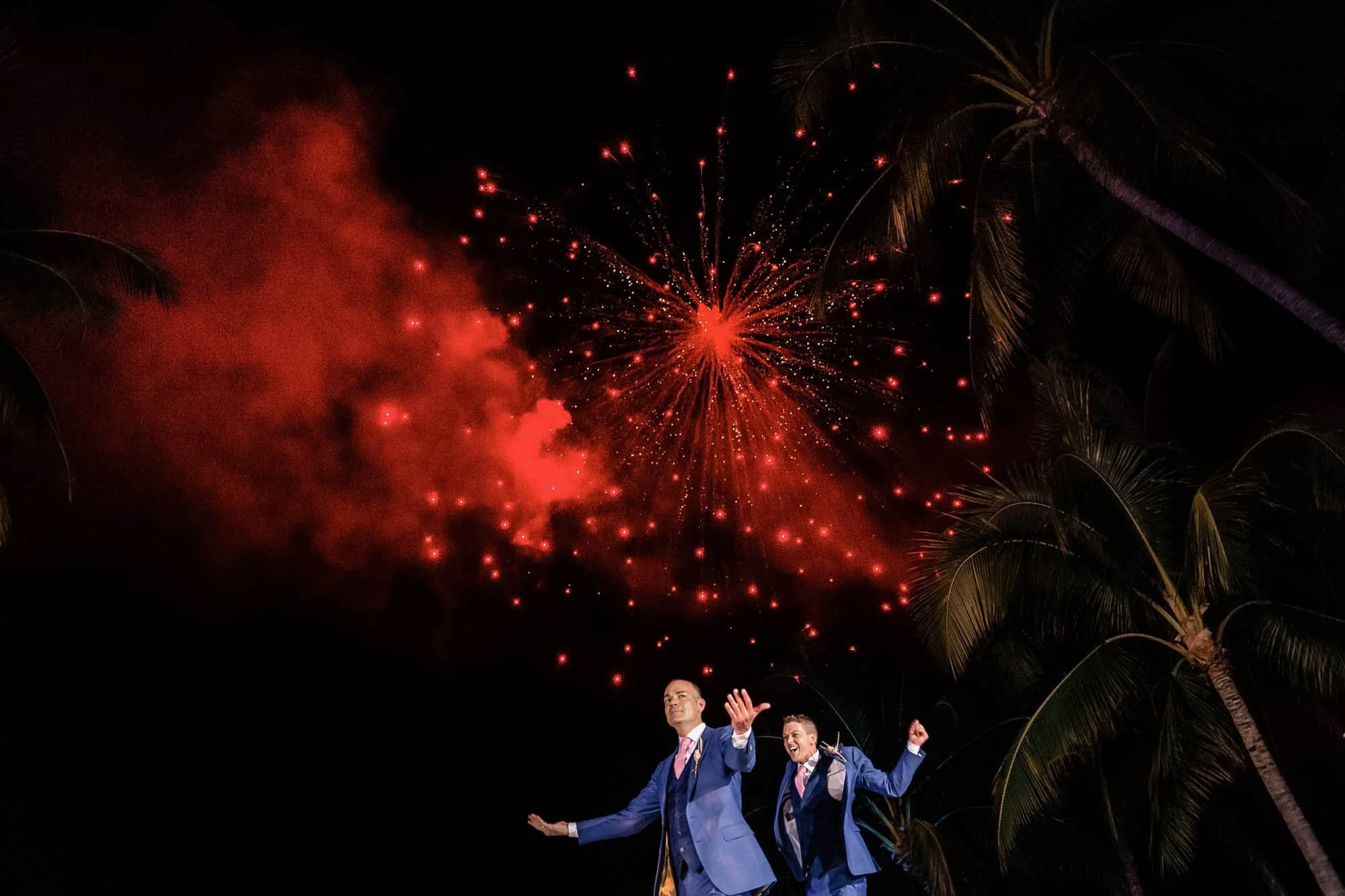 Exciting fireworks during the first dance of a gay couple at their beach destination wedding.