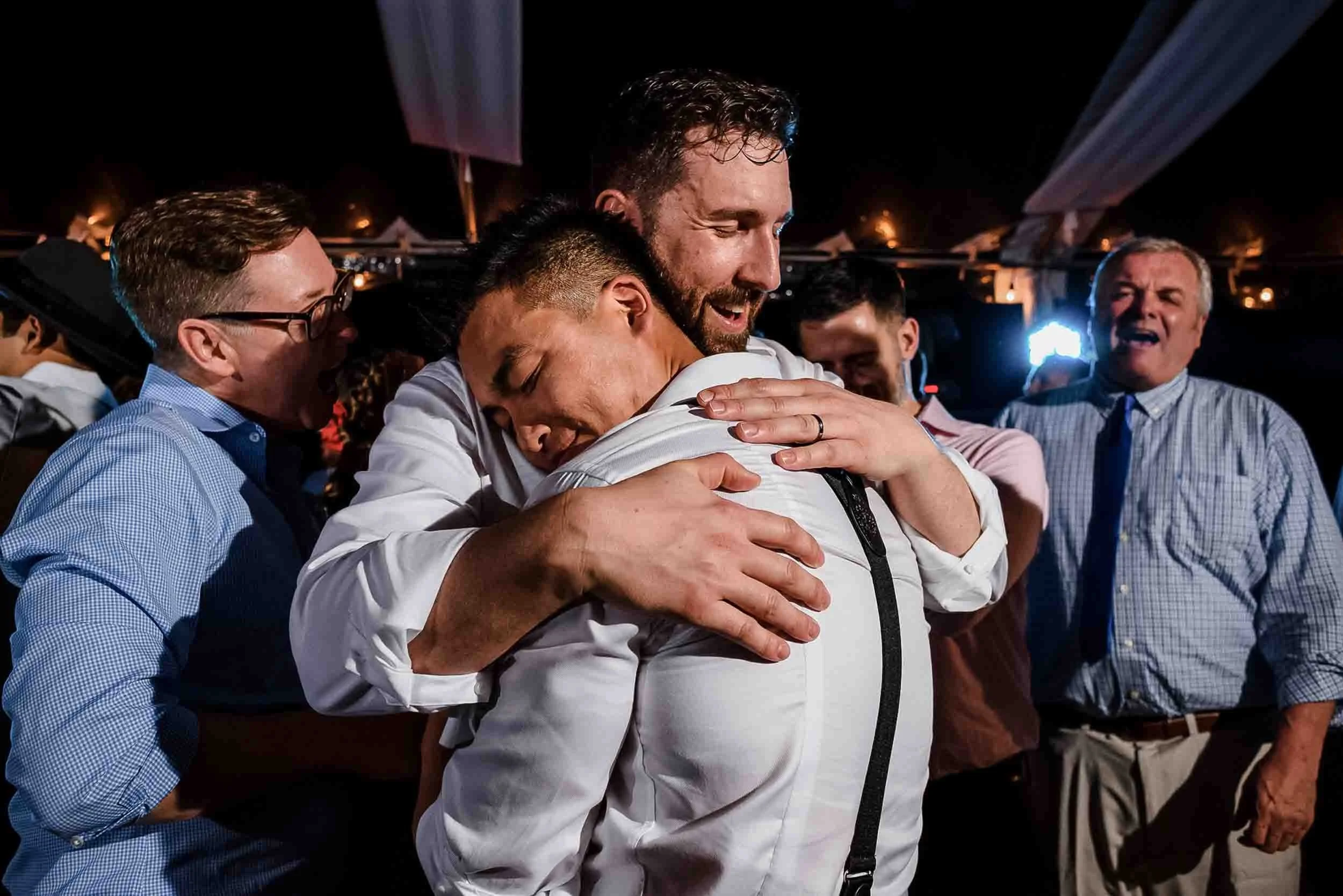 Grooms lovingly hugging on the dance floor during the reception of their wedding at the Hyatt Ziva resort in Puerto Vallarta