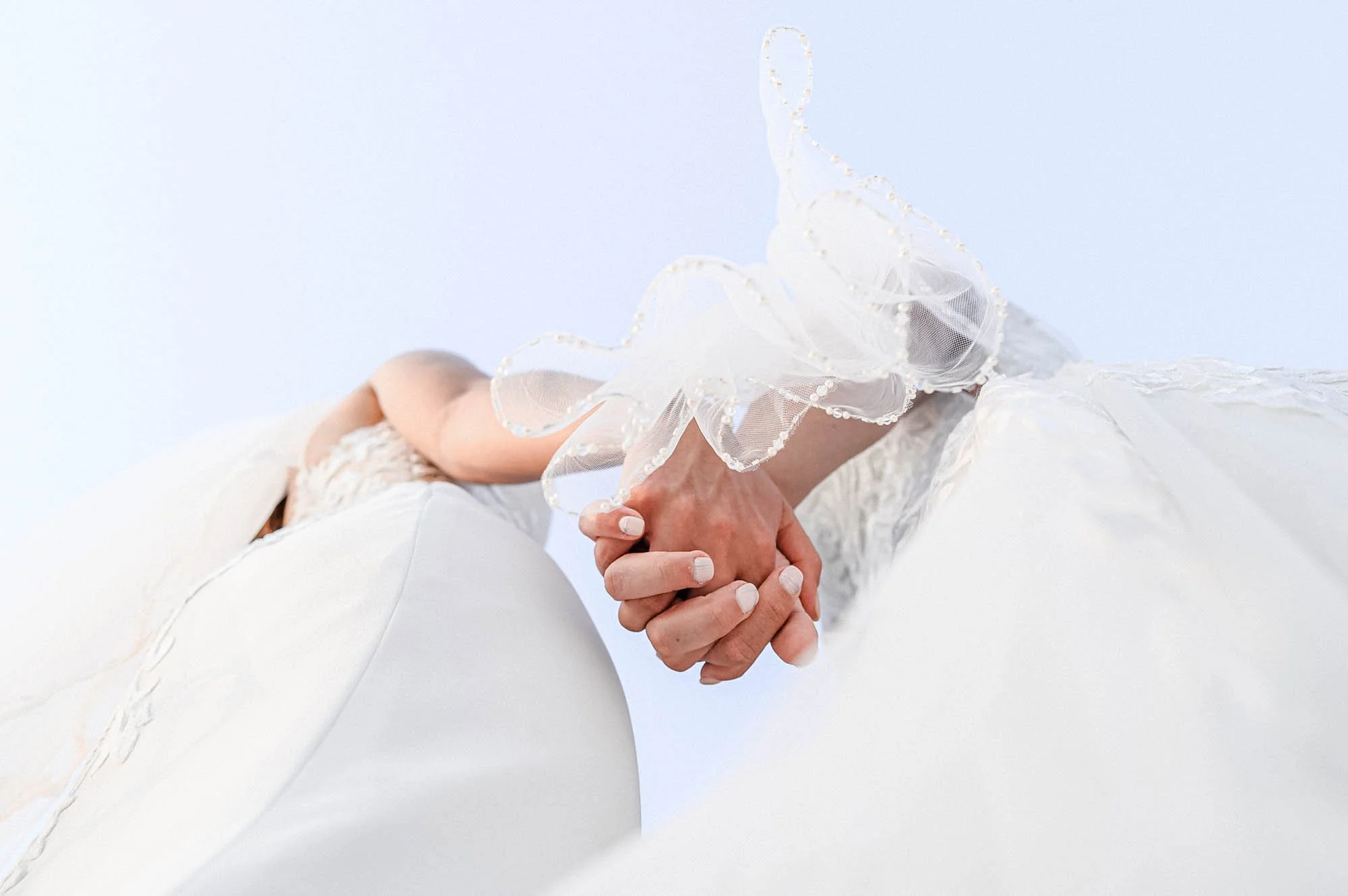 Detail of lesbian brides holding hands