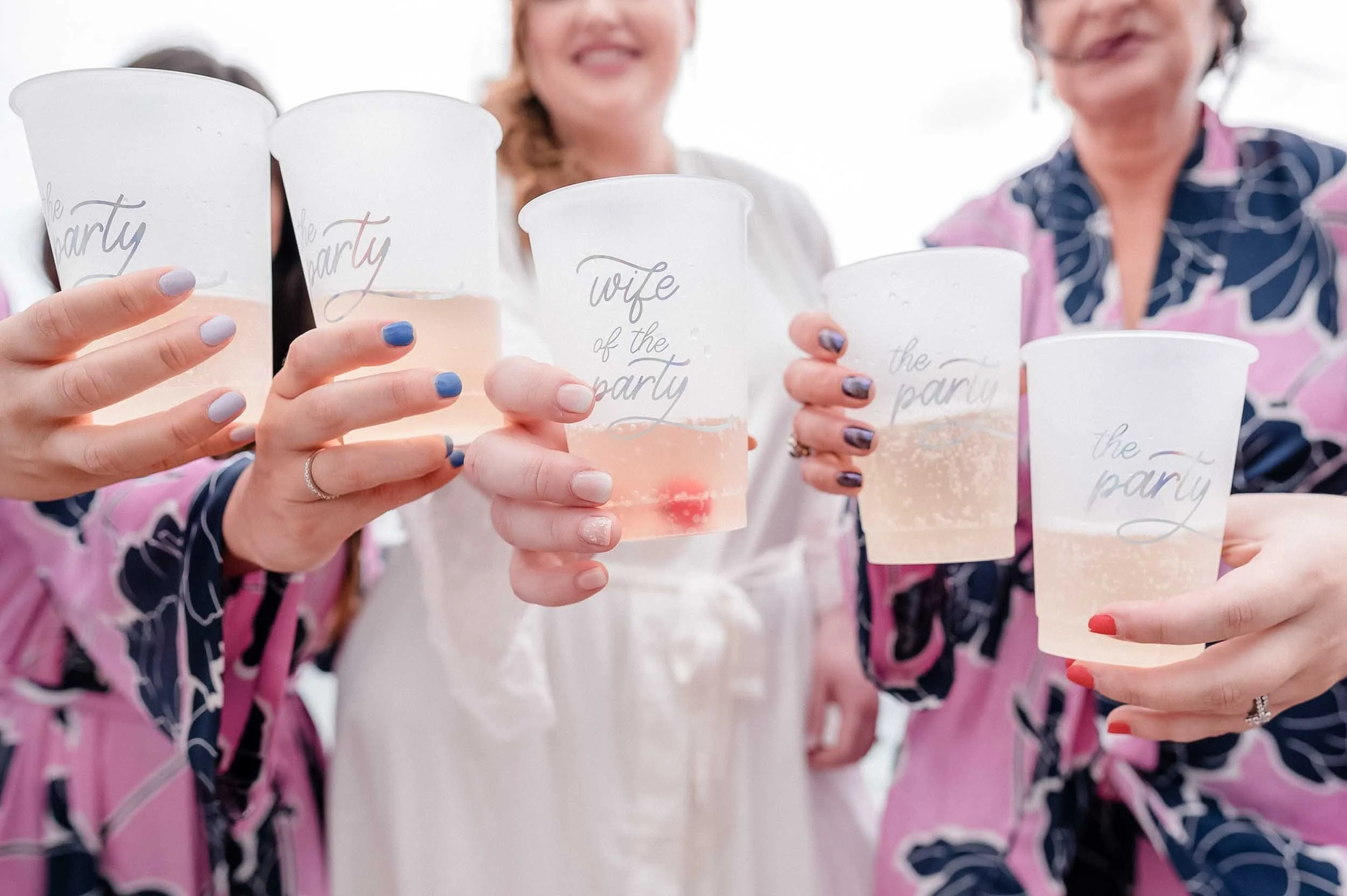 Bride and bridesmaids toasting during getting ready for the wedding.