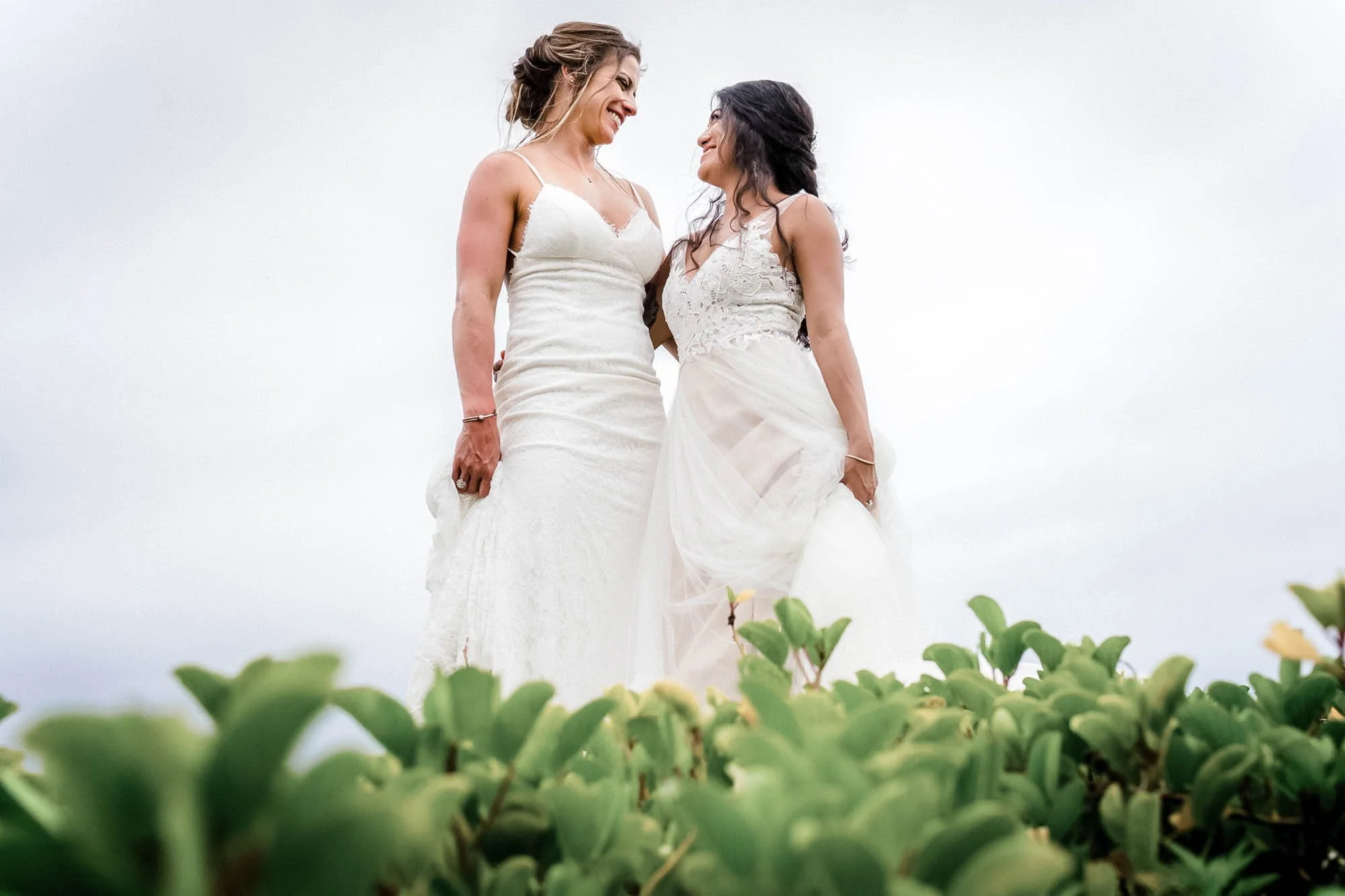Beautiful lesbian brides posing for portraits at the beach at the Velas Resort.