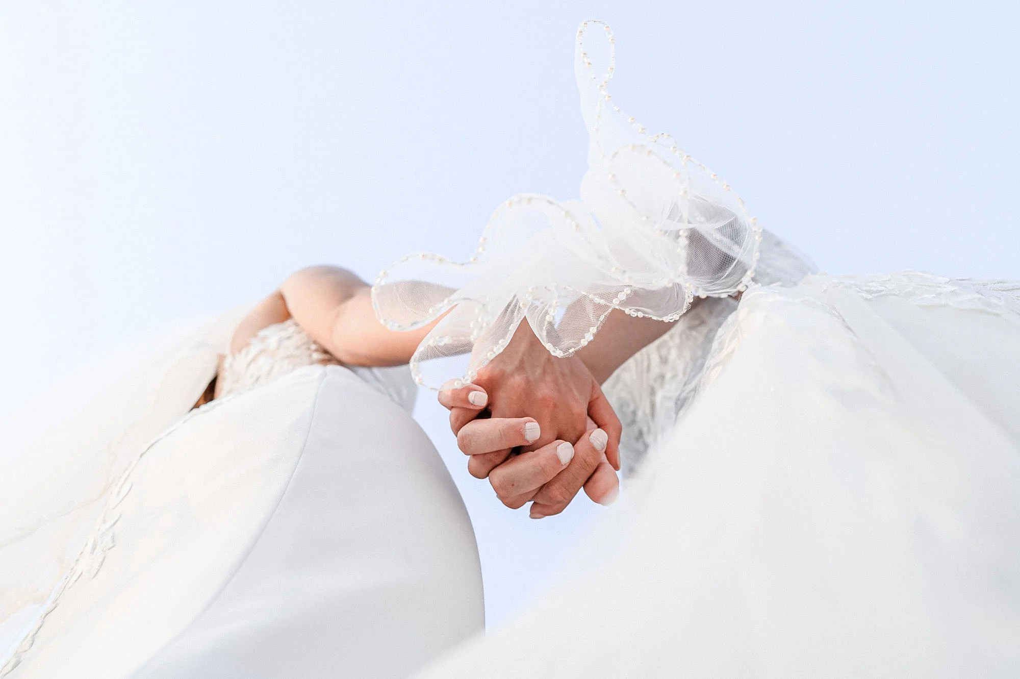 Detail of lesbian brides holding hands