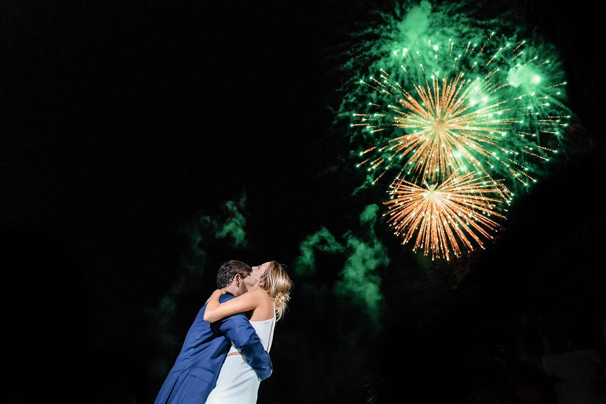Fireworks during first dance at wedding with bride and groom full of joy.