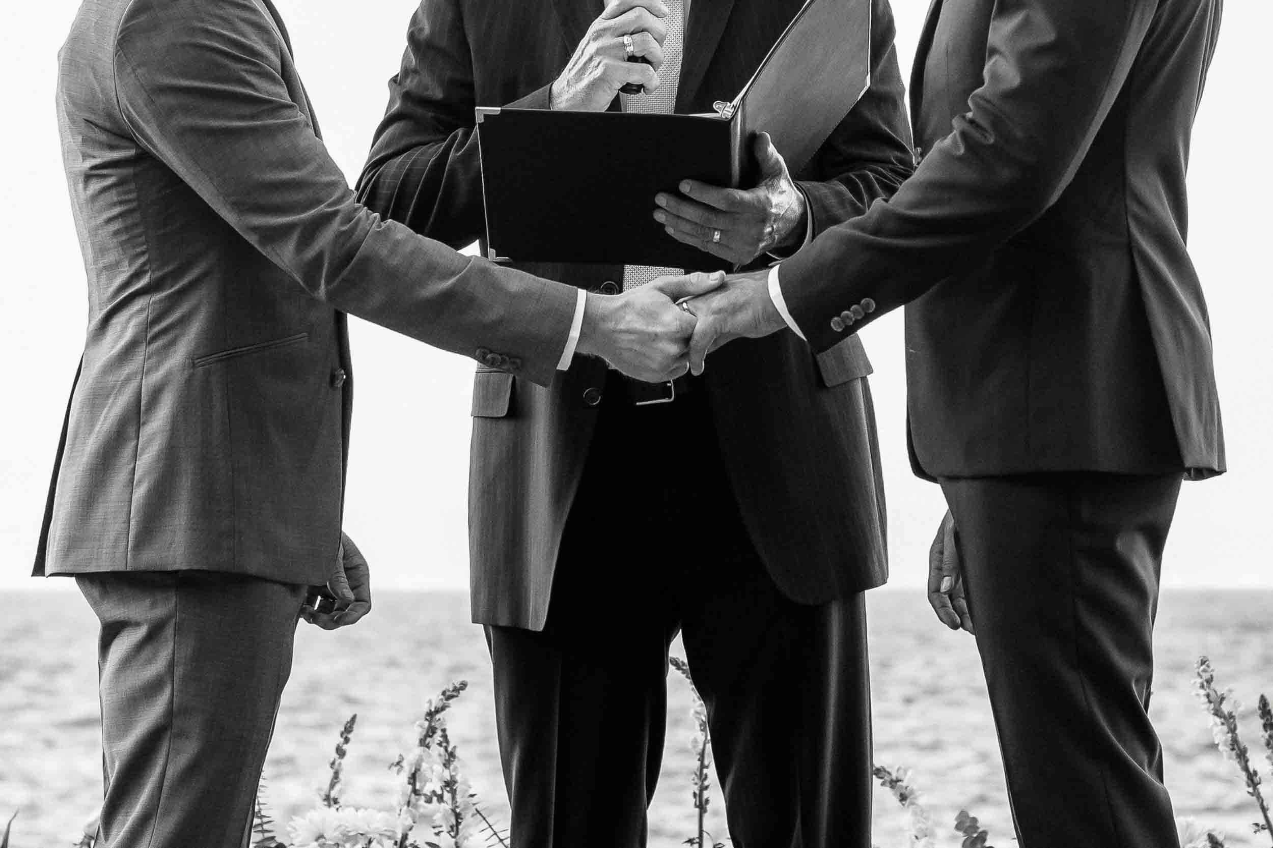 Grooms holding hands after ring exchange in their wedding ceremony held in Puerto Vallarta