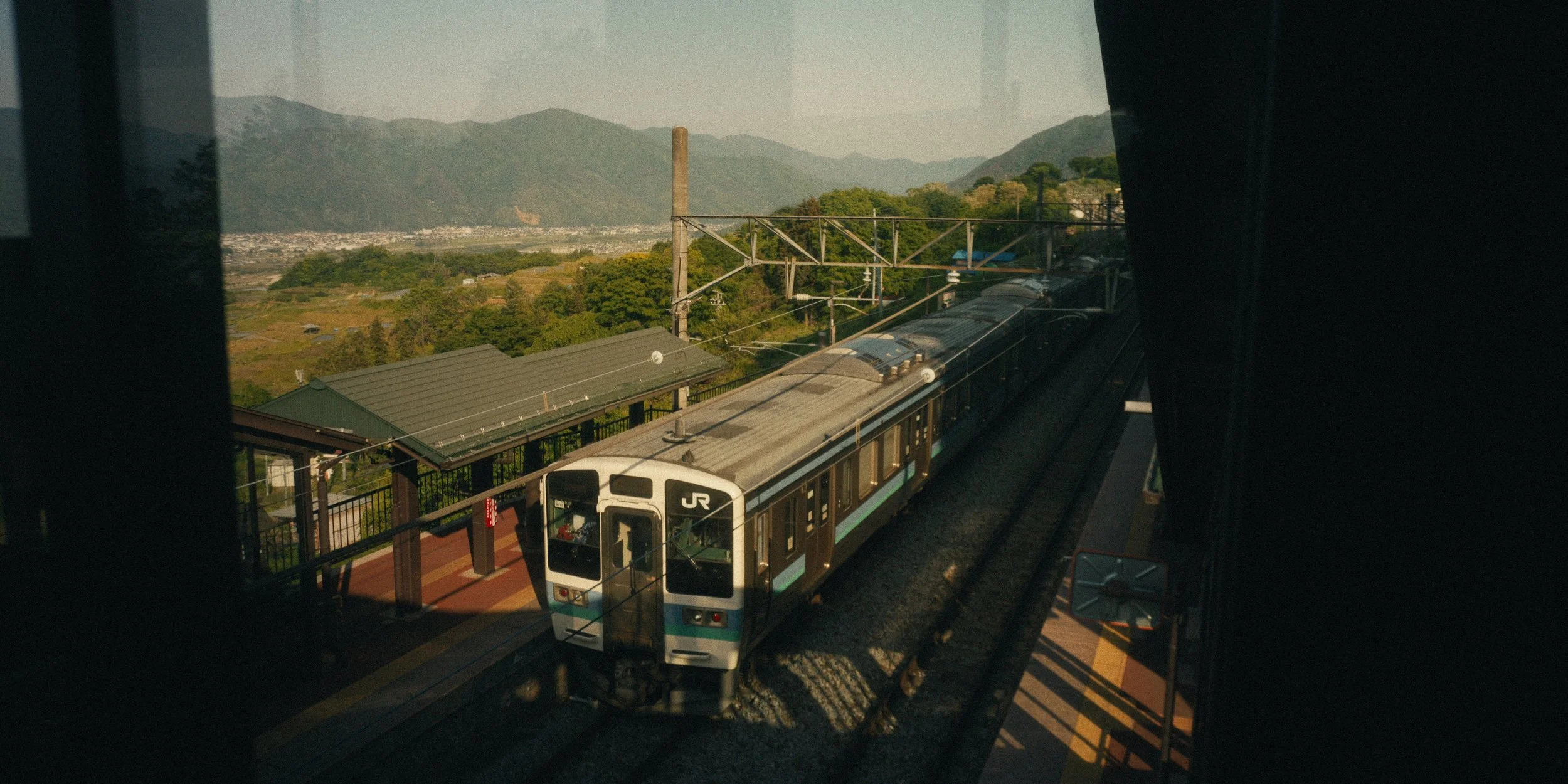 A train traveling on an elevated track with a scenic mountain landscape in the background.