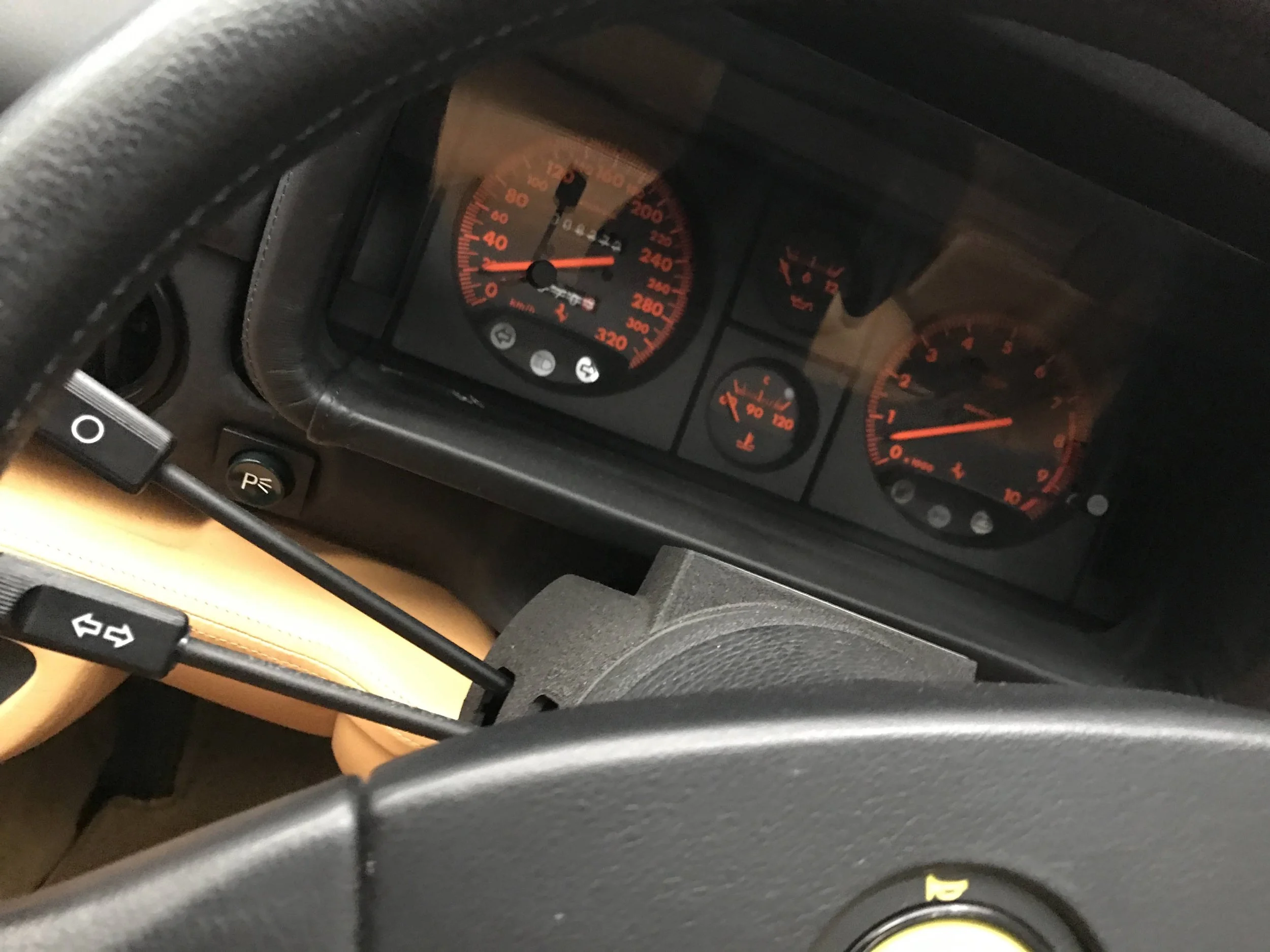 View of a car dashboard showing speedometer, tachometer, fuel gauge, and temperature gauge with all needles pointing to various levels.