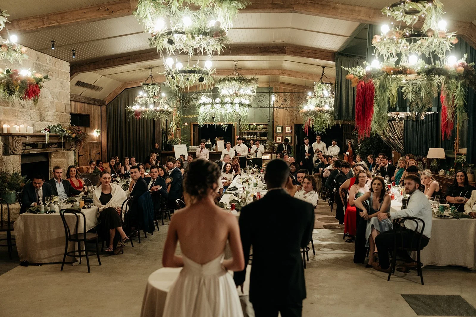 A wedding reception at The Barn at Saddles Mount White with a bride and groom standing before guests.