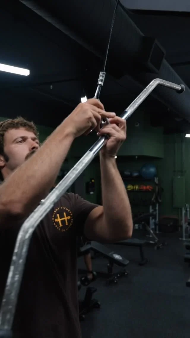 Personal Trainer Taylor Smith installing a heavy‑duty metal training bar inside Haus of Fitness in Oceanside, San Diego.  
Strength coach Taylor reinforces gym equipment to support advanced training sessions, and functional strength work