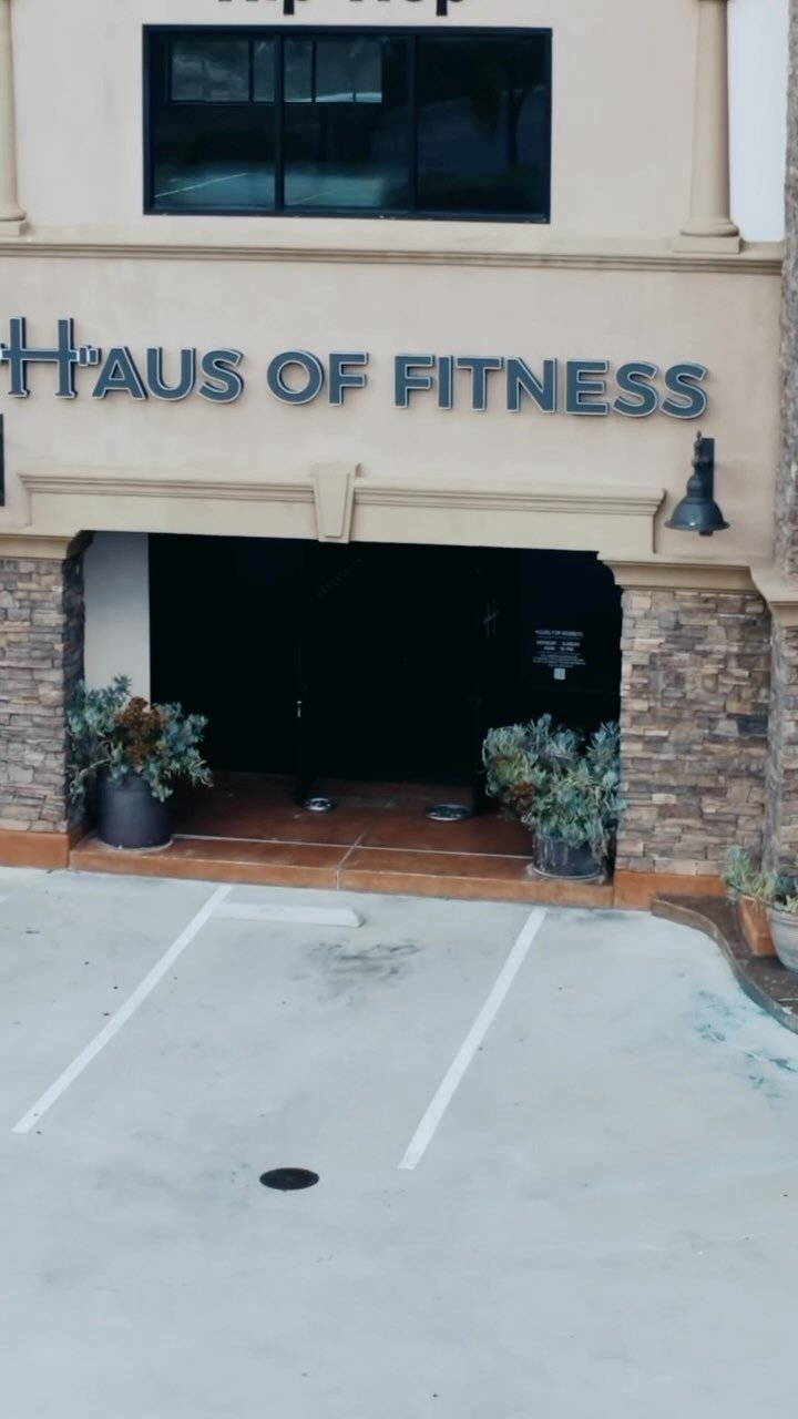 Front entrance of Haus of Fitness in Oceanside, San Diego — a modern personal training studio with clean landscaping, potted plants, and convenient parking directly in front of the facility.