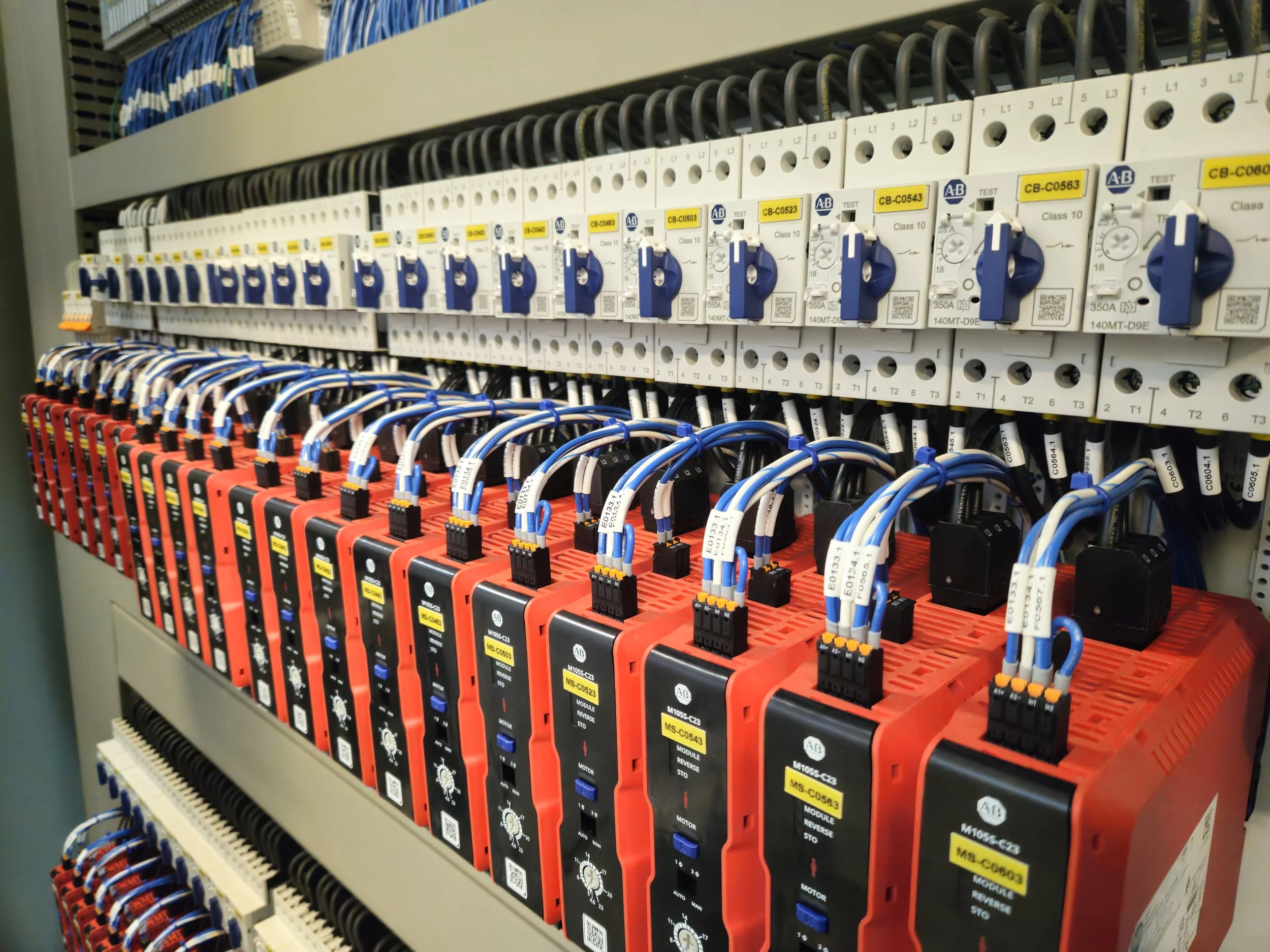 An electrical control panel featuring various circuit breakers, switches, and wiring organized in rows.