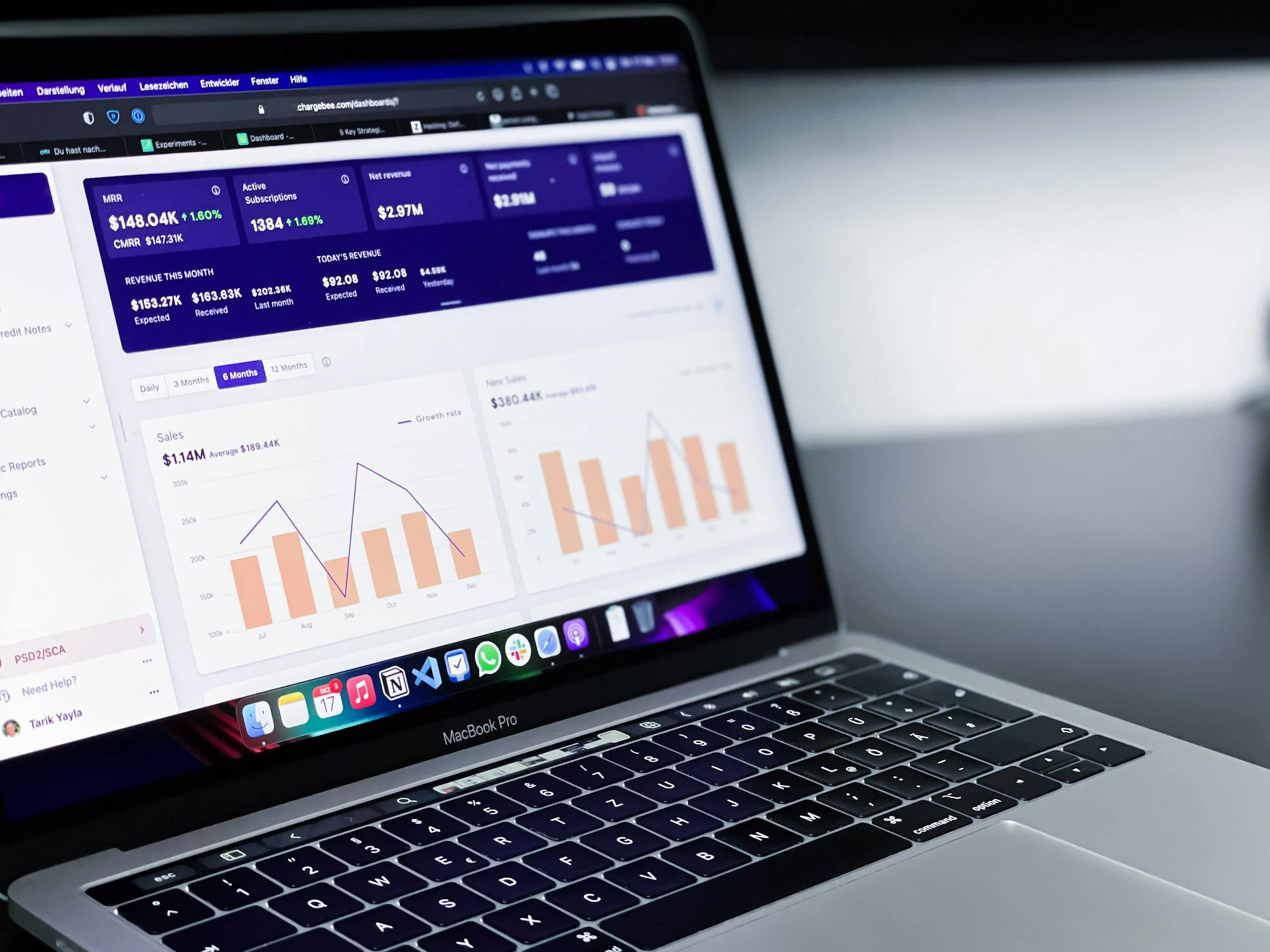 A MacBook Pro laptop displaying financial data and graphs on its screen.