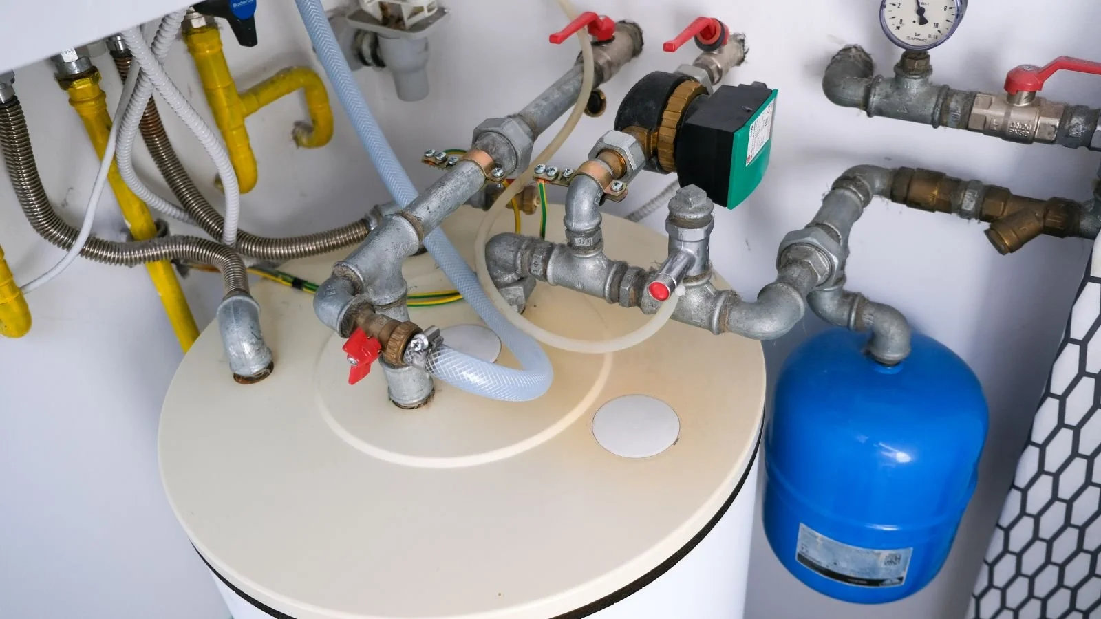 A network of plumbing pipes, valves, and gauges connected to a water filtration or heating system.